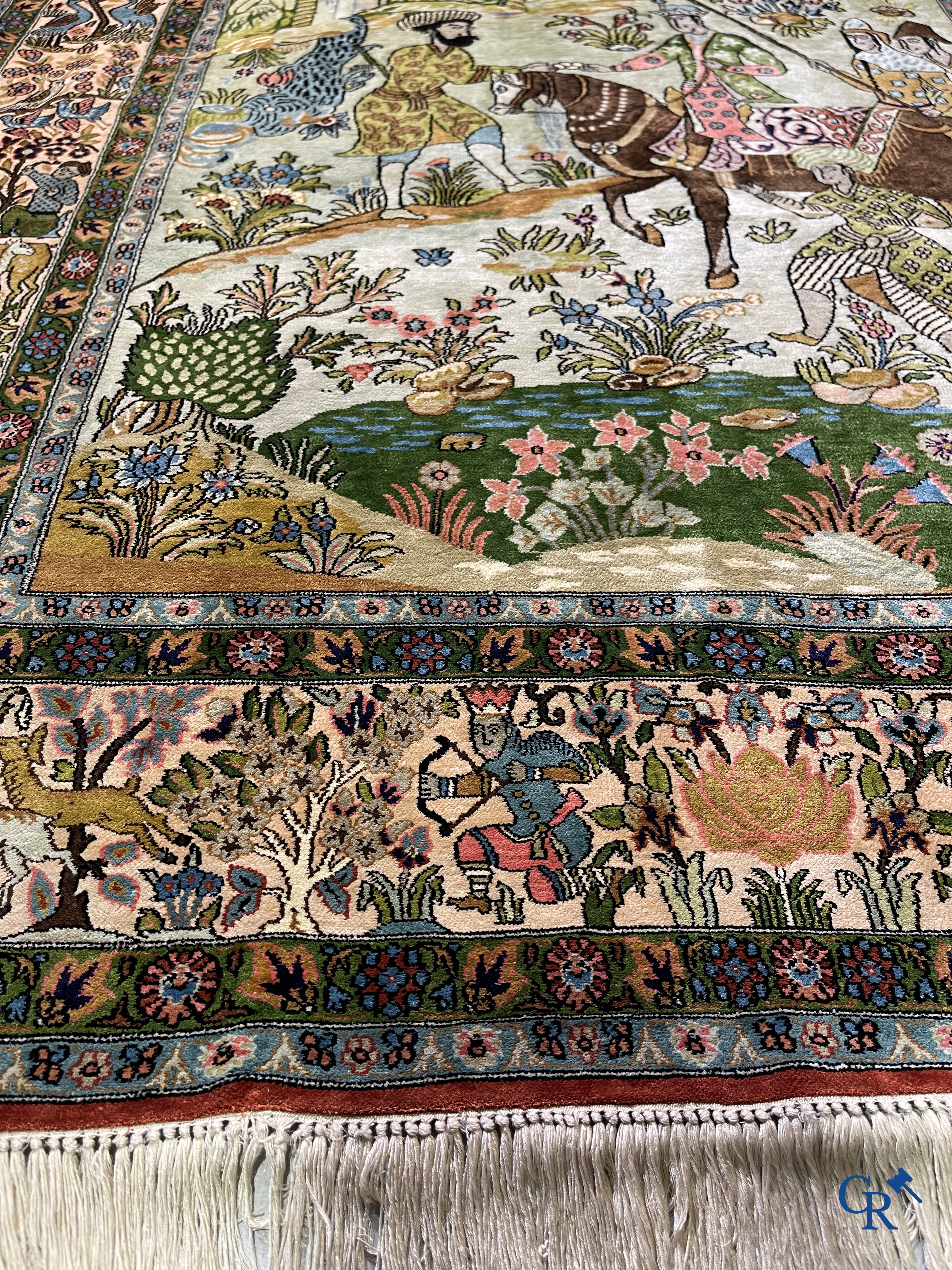 Tapis d'Orient. Iran. Un tapis persan en soie finement noué à la main avec des personnages et un cheval dans un paysage.