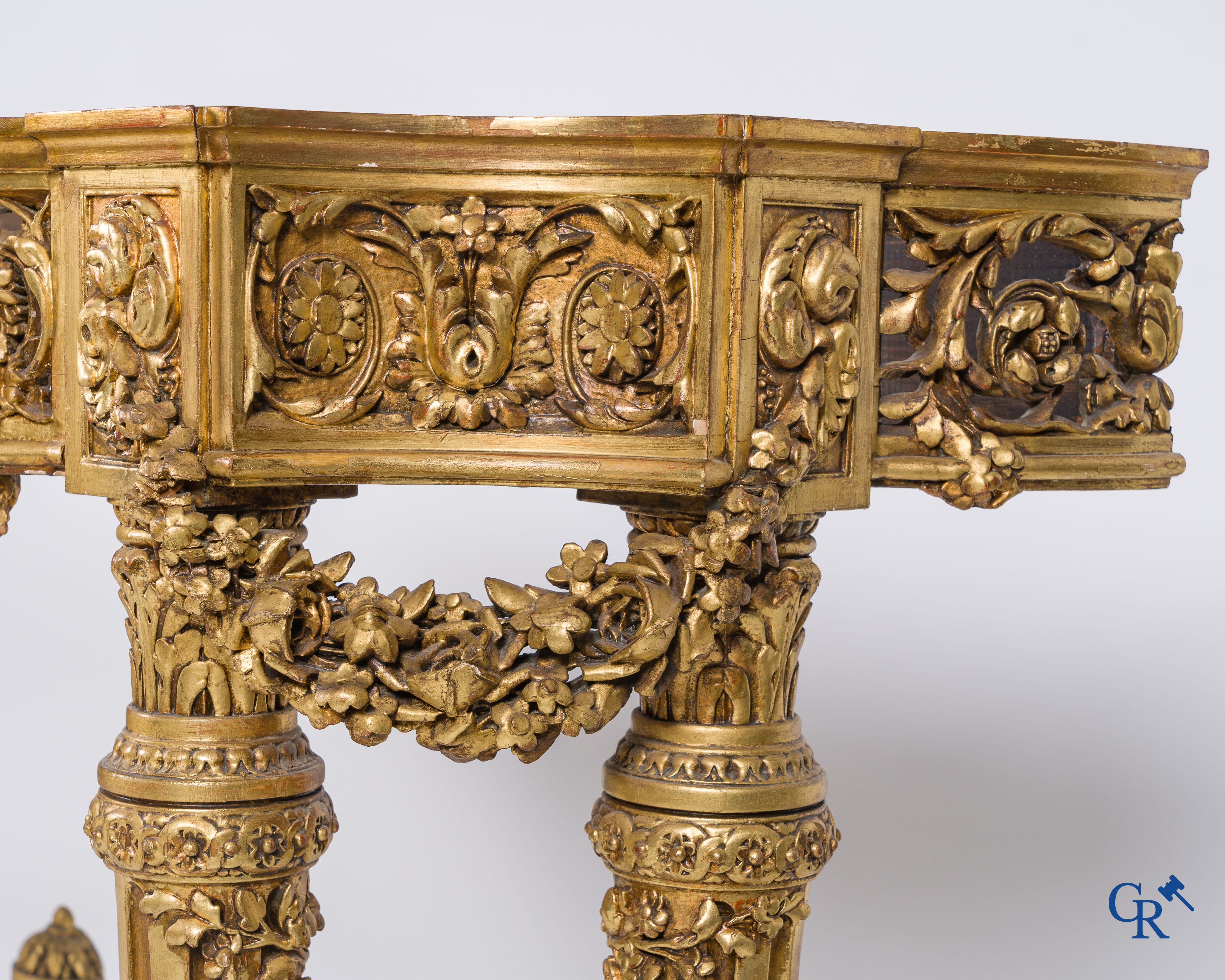 A richly carved and gilded console table in LVXI style with a grisaille painting on marble.