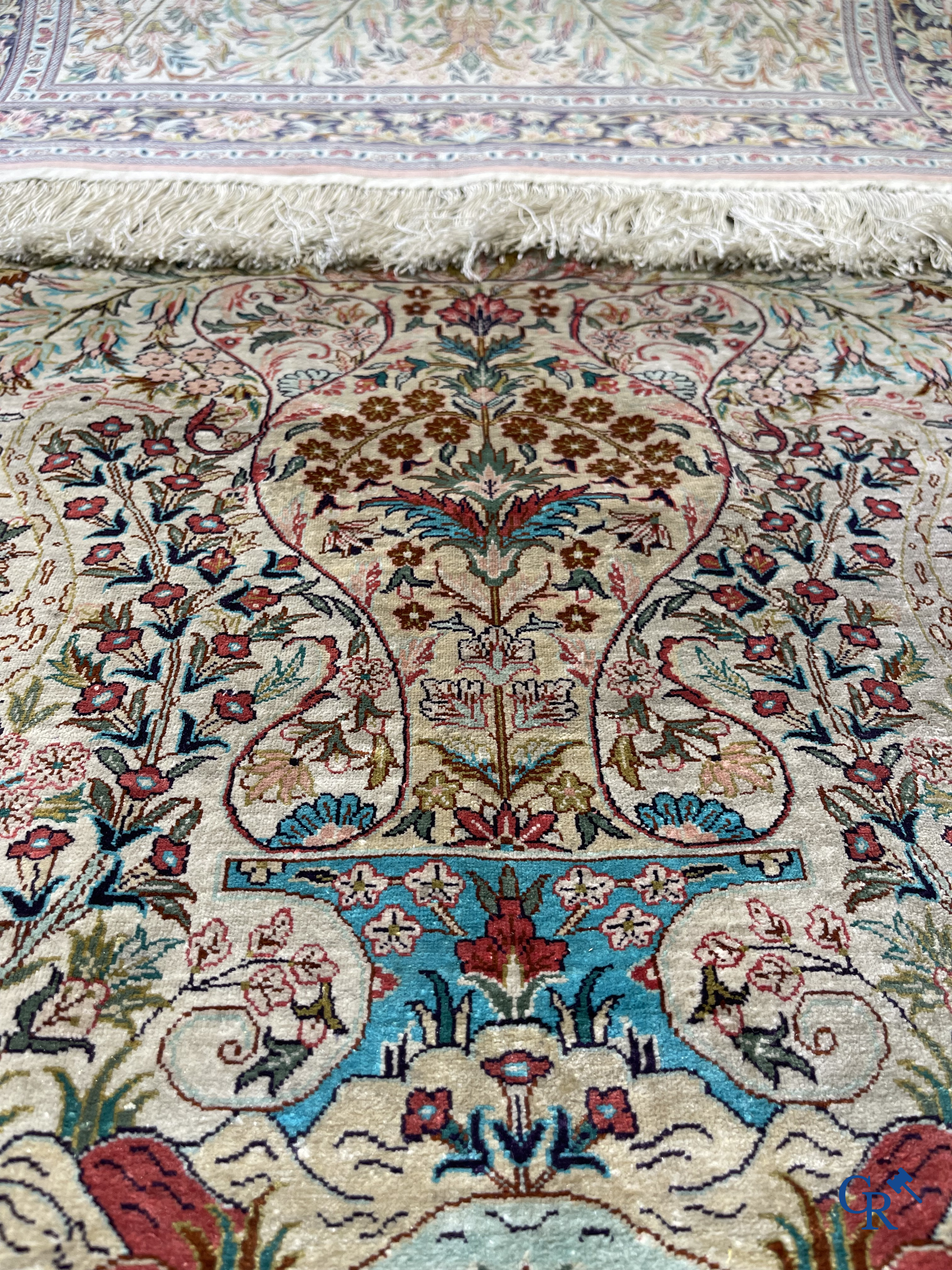 Tapis d'Orient: Un tapis persan en soie finement noué à la main avec un vase à fleurs et des oiseaux dans un décor floral.