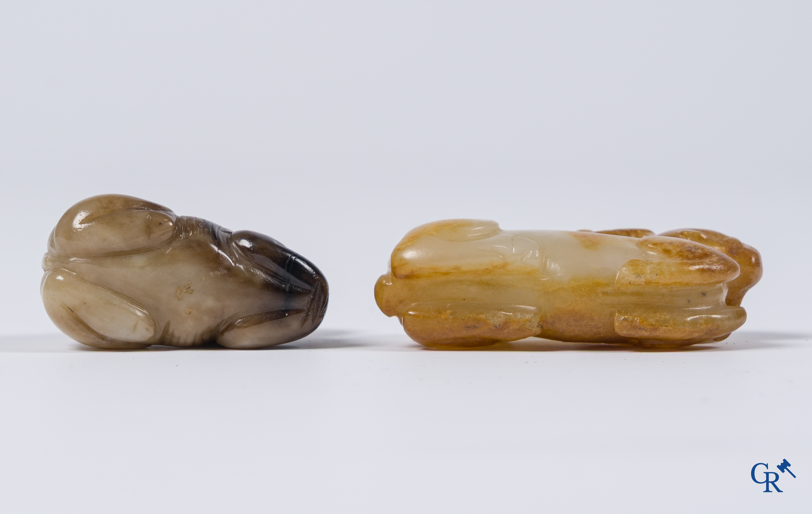 Aziatica. Een bleek celadon en roestbruin kleurige jade hertengroep en een bruinkleurig mythisch beest in jade.