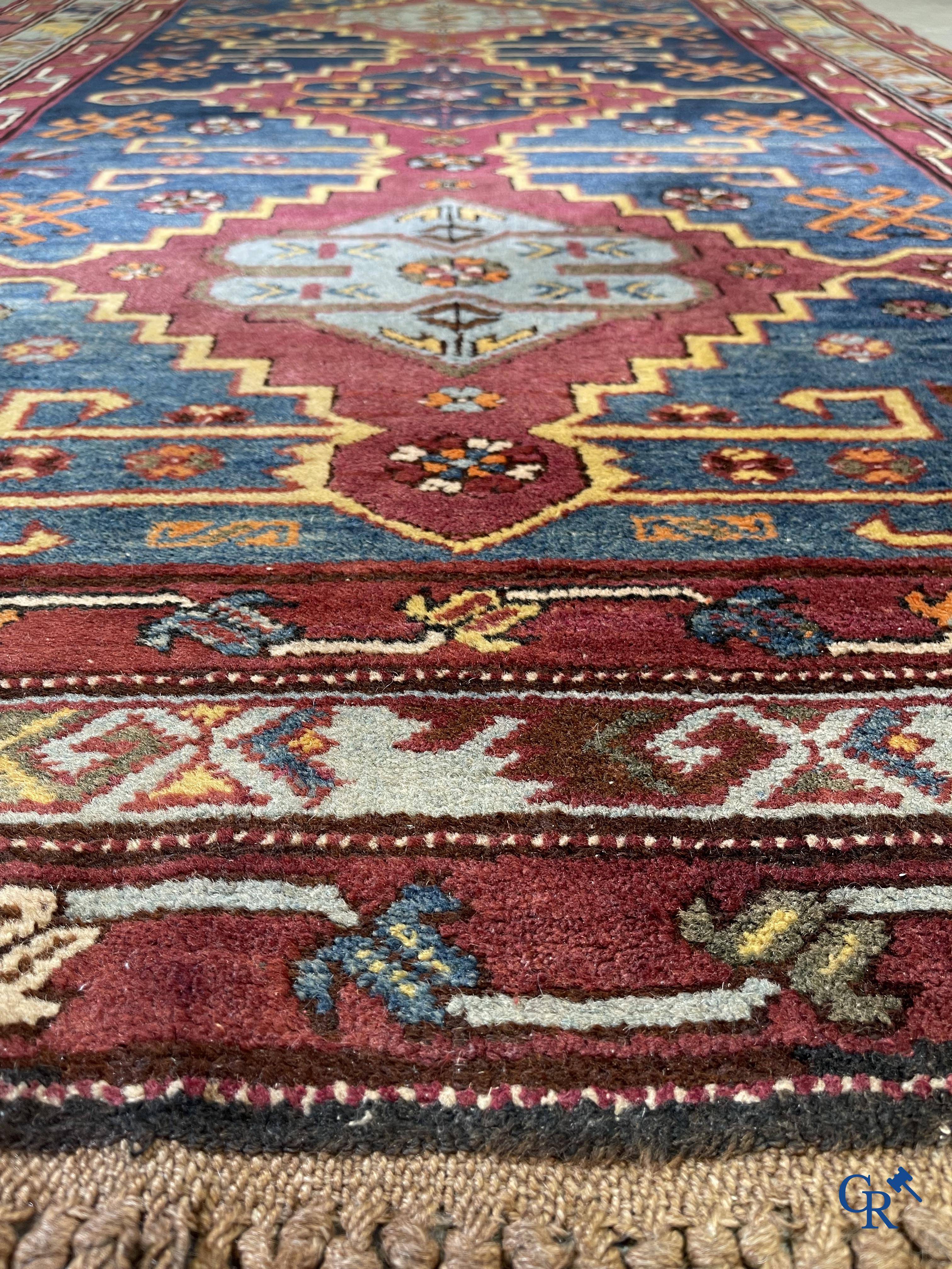 Oriental carpets, an antique hand-knotted Oriental carpet with motifs on a blue background.