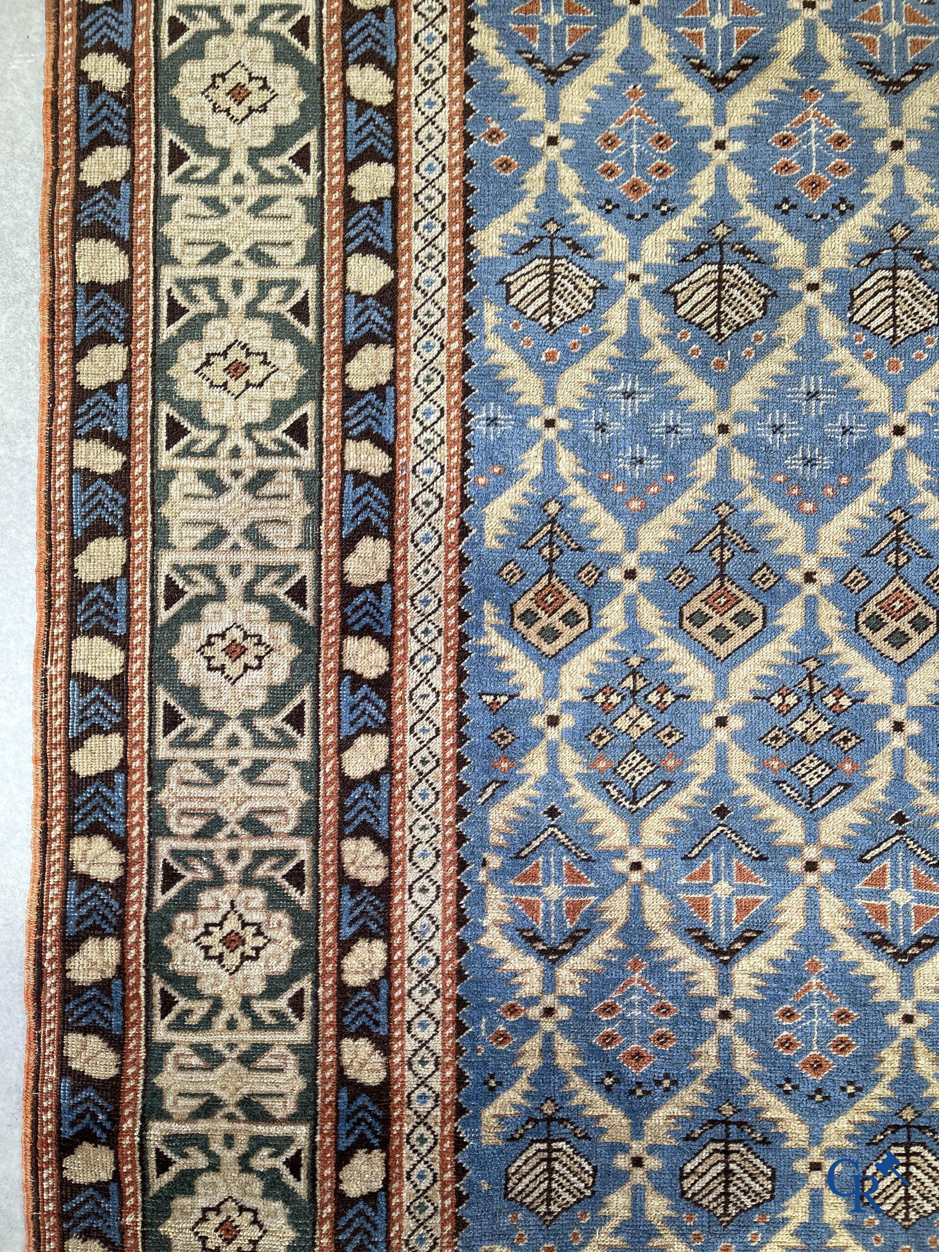 Antique Oriental carpets, an antique Dagestan carpet with motifs on a blue background.