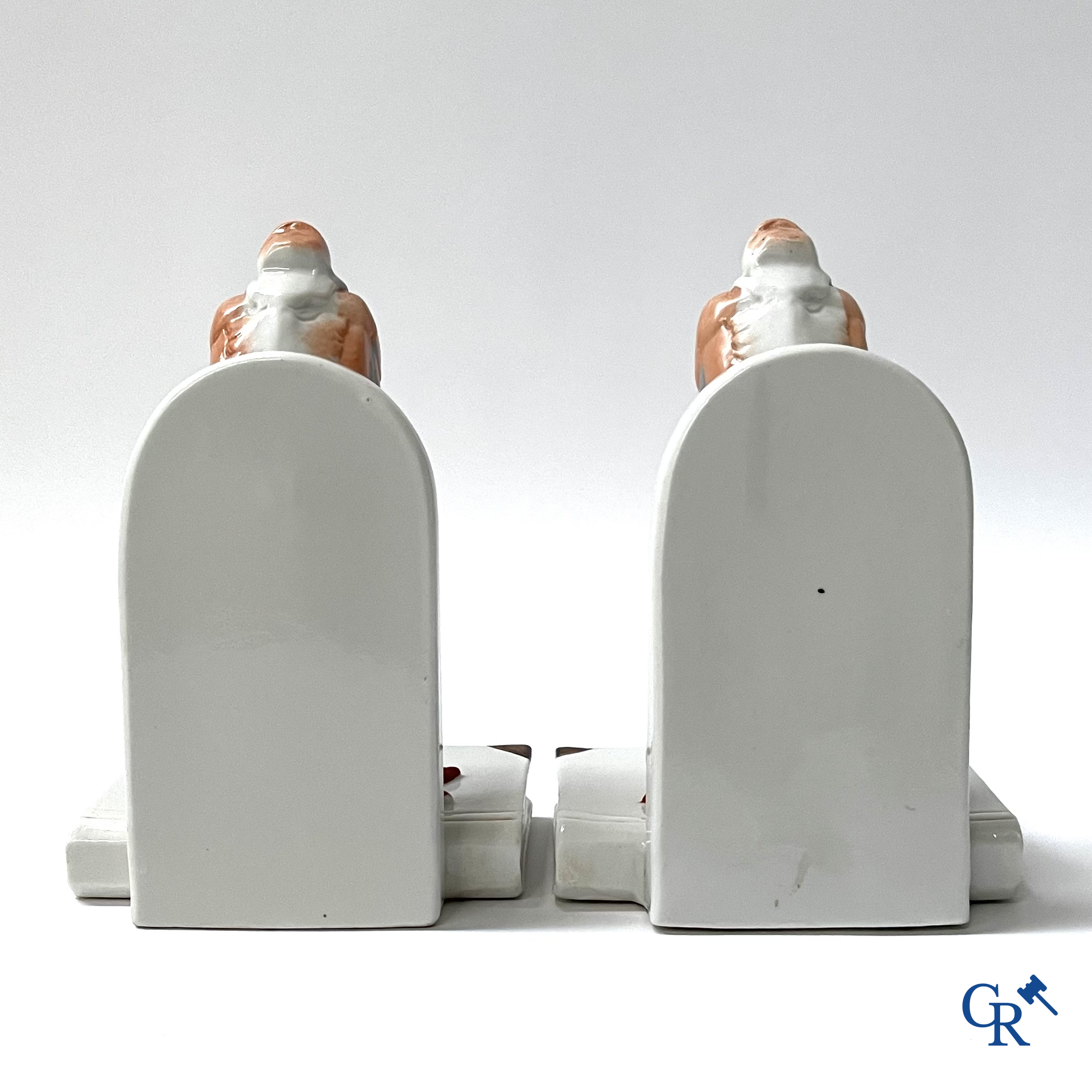 Art Deco, een paar boekensteunen in gepolychromeerd porselein met een typische Art deco voorstelling van maraboes.