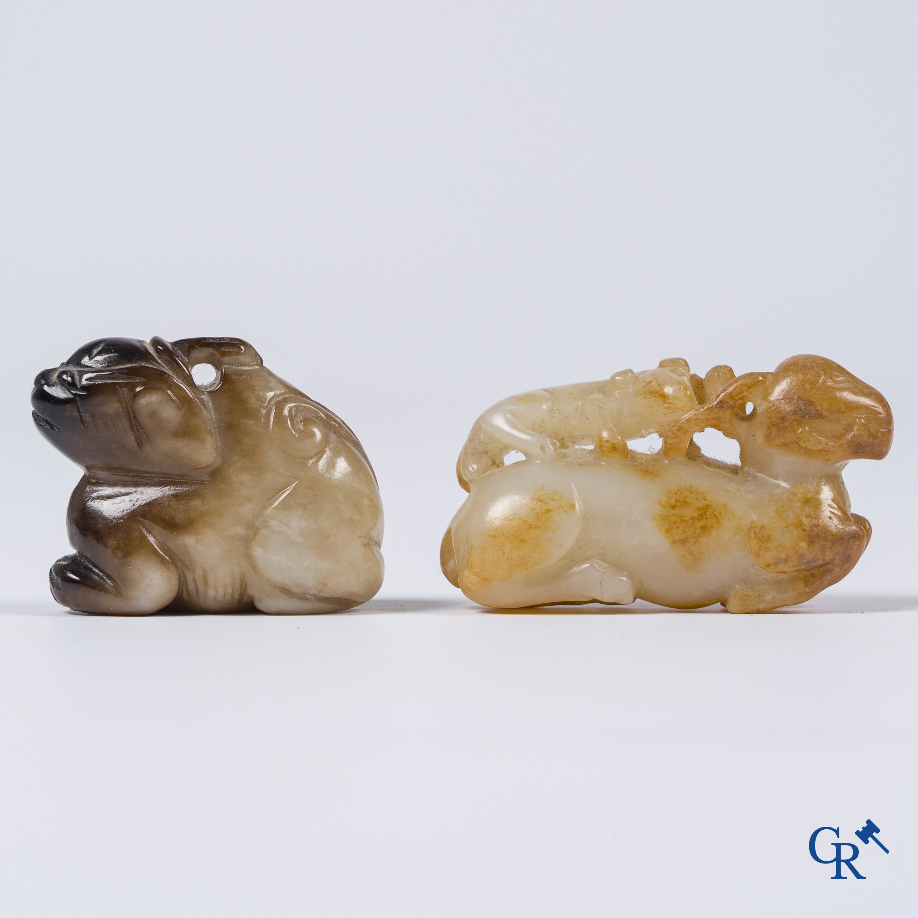 Aziatica. Een bleek celadon en roestbruin kleurige jade hertengroep en een bruinkleurig mythisch beest in jade.