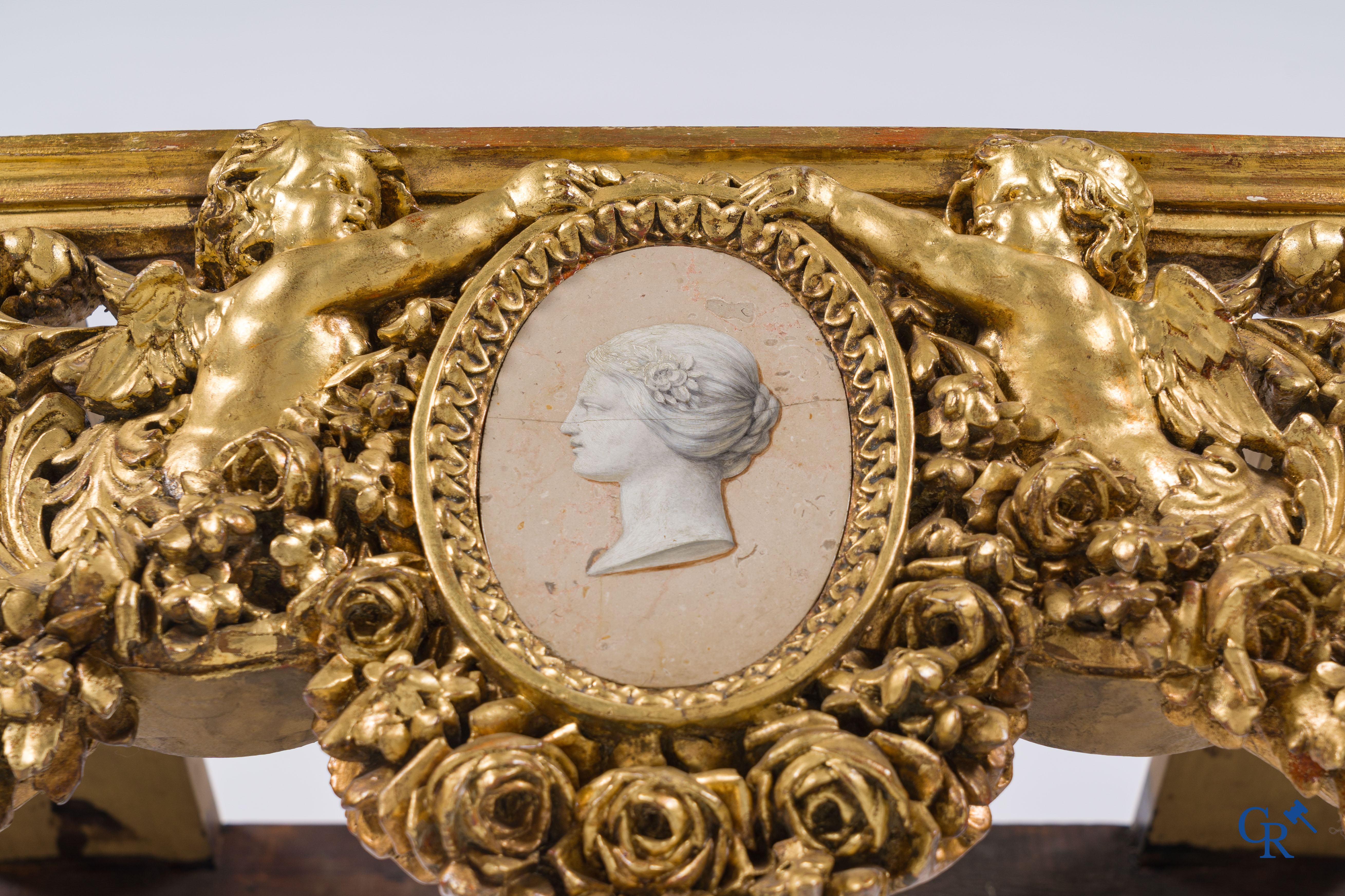 A richly carved and gilded console table in LVXI style with a grisaille painting on marble.