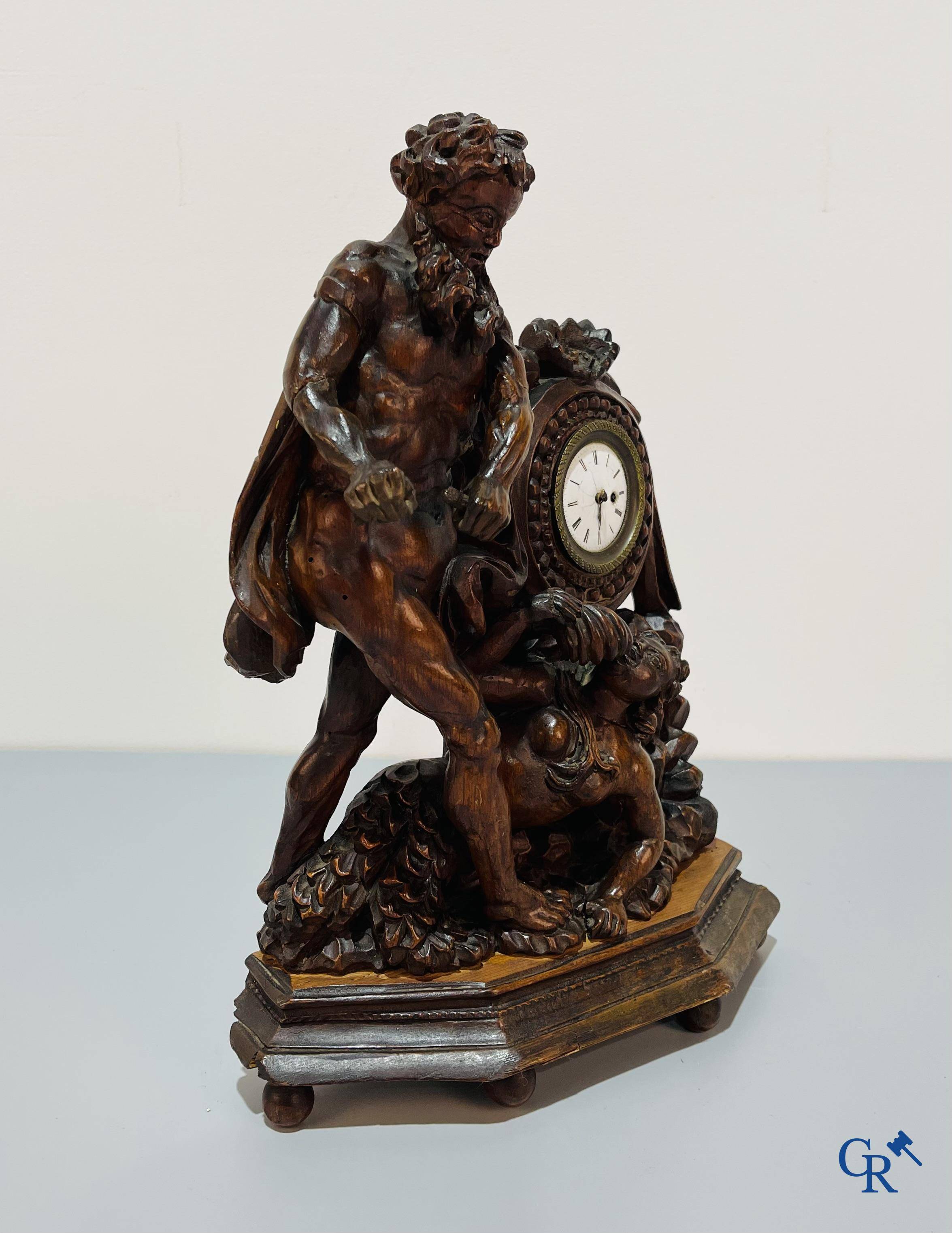 An 18th century wood carved table clock with finely chiseled English watchwork.