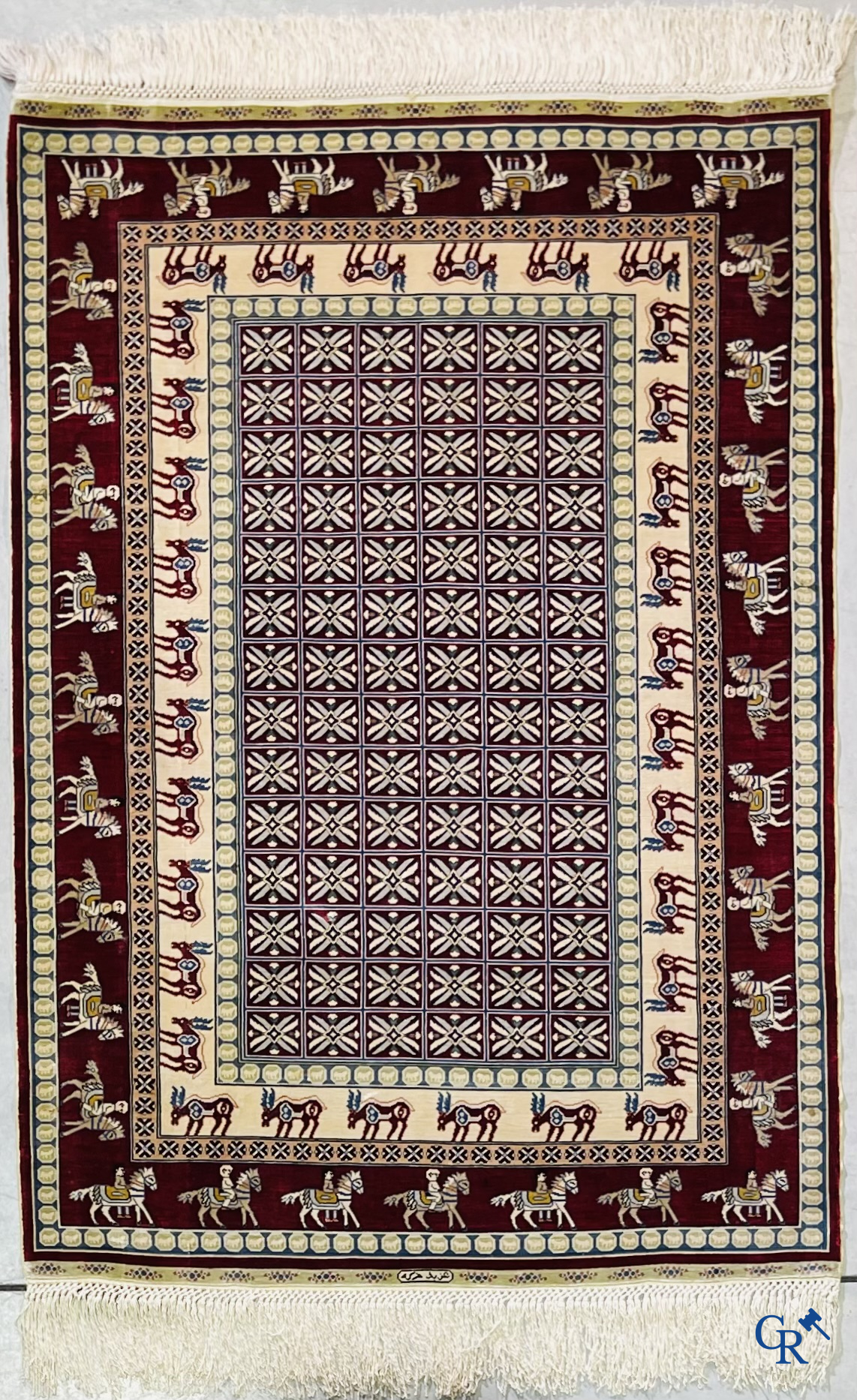 Oriental rugs: A small finely hand-knotted silk rug with deer and horsemen. Signed.