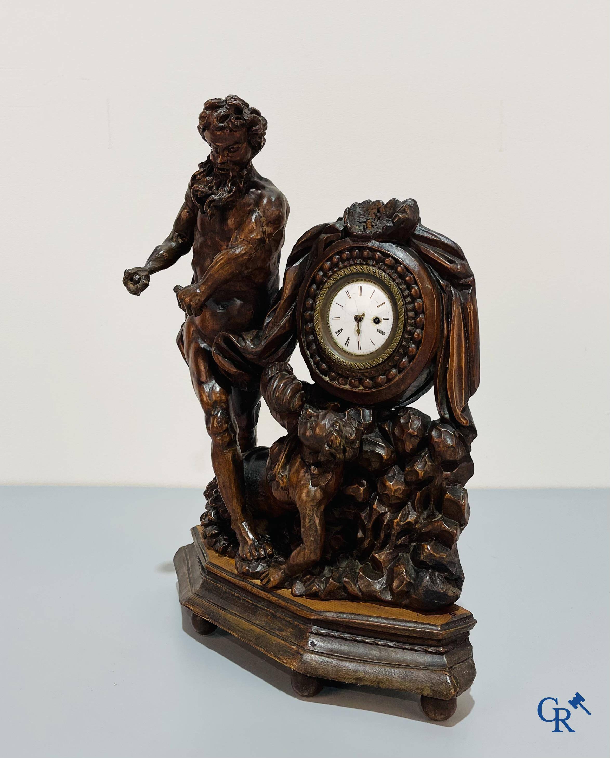 An 18th century wood carved table clock with finely chiseled English watchwork.