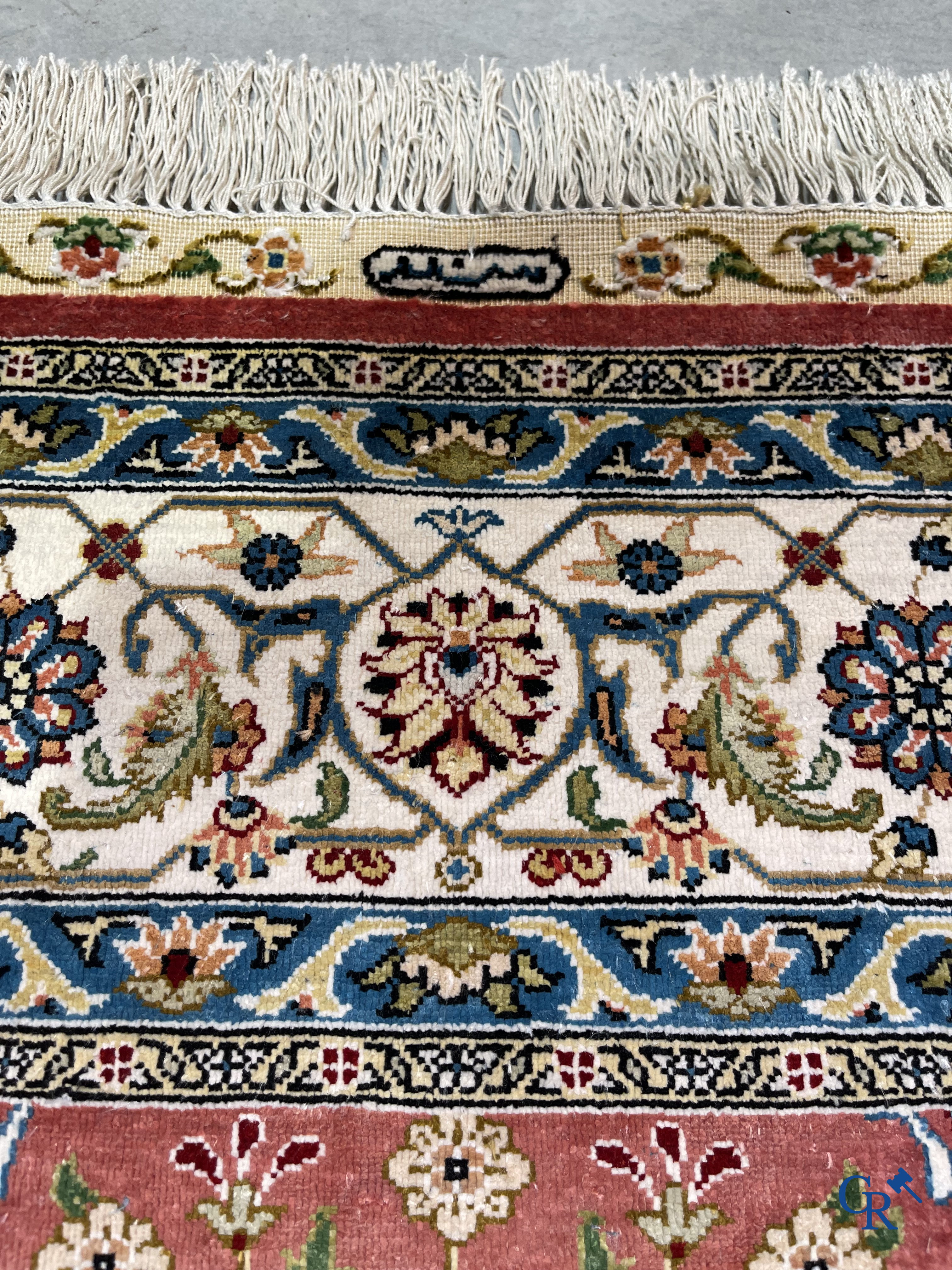 Tapis d'Orient: Un tapis finement noué à la main en laine et soie avec un décor floral.<br />
Signé.