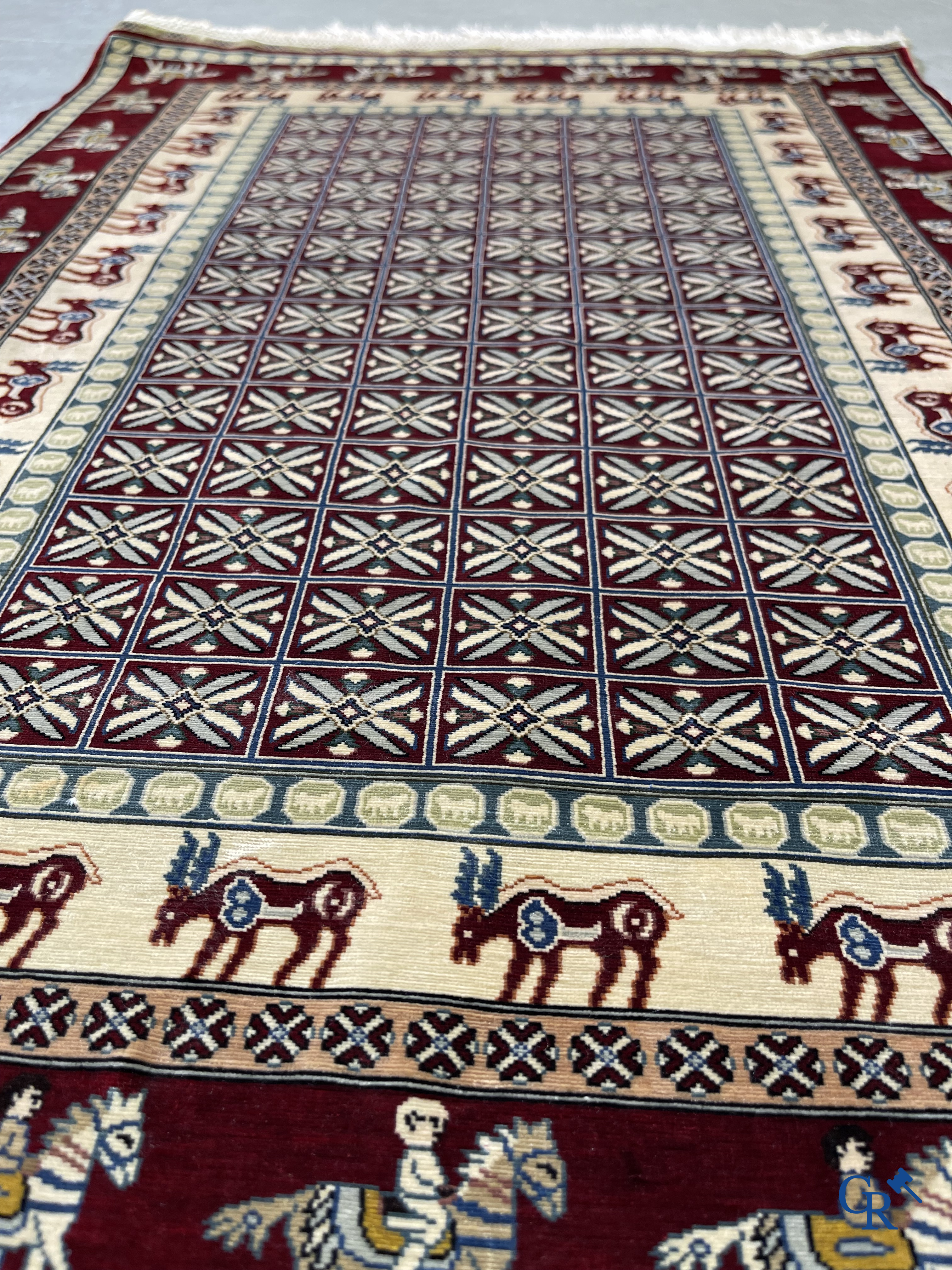 Oriental rugs: A small finely hand-knotted silk rug with deer and horsemen. Signed.