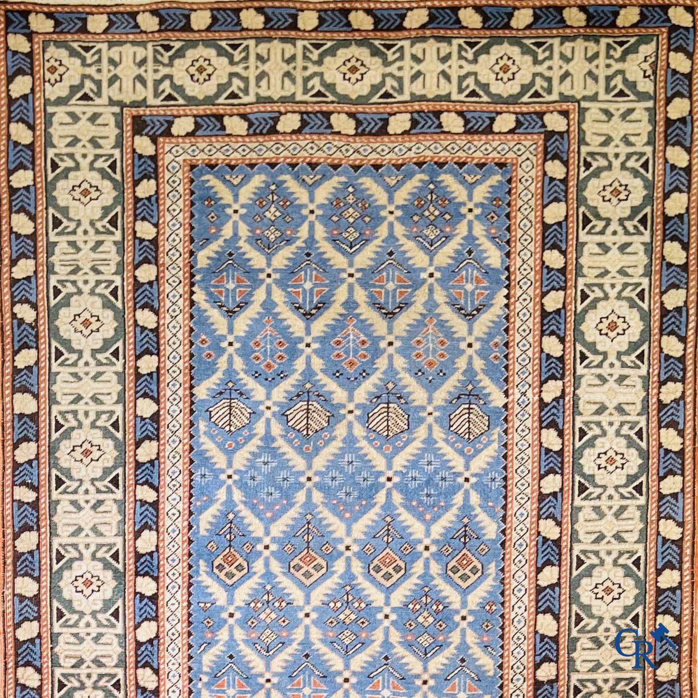 Antique Oriental carpets, an antique Dagestan carpet with motifs on a blue background.