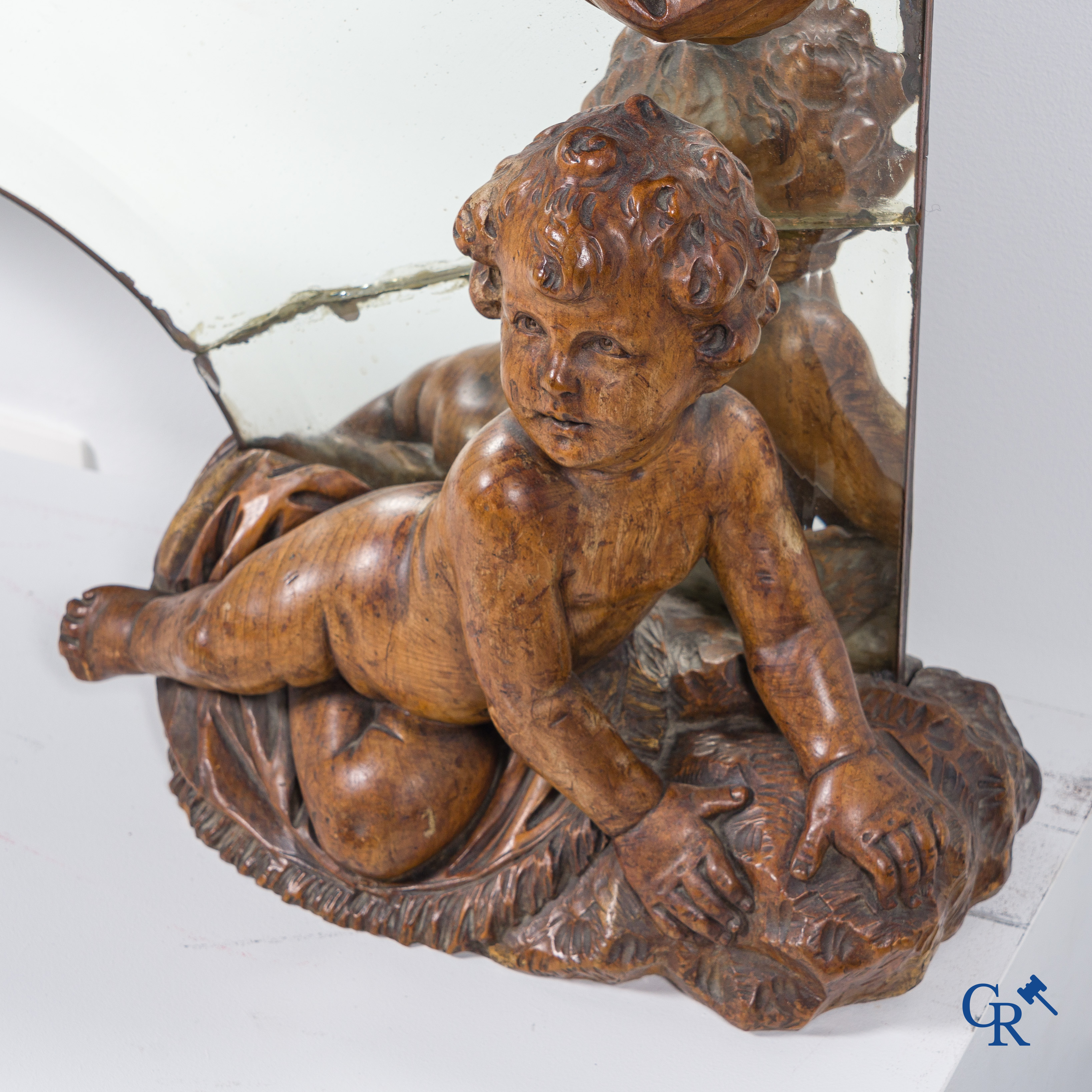 Un grand miroir entouré de 6 putti en bois sculpté. Vers 1900.