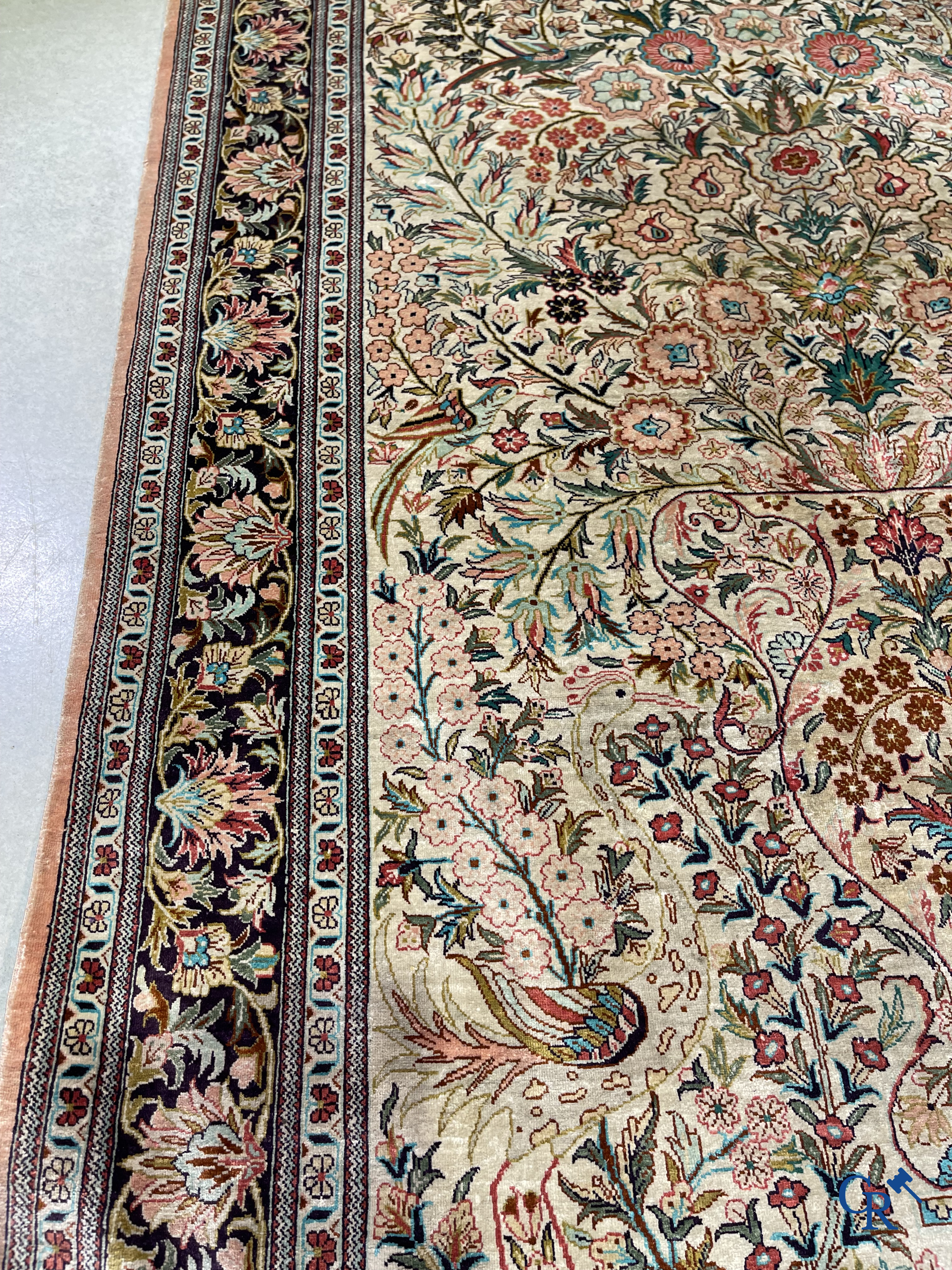 Tapis d'Orient: Un tapis persan en soie finement noué à la main avec un vase à fleurs et des oiseaux dans un décor floral.