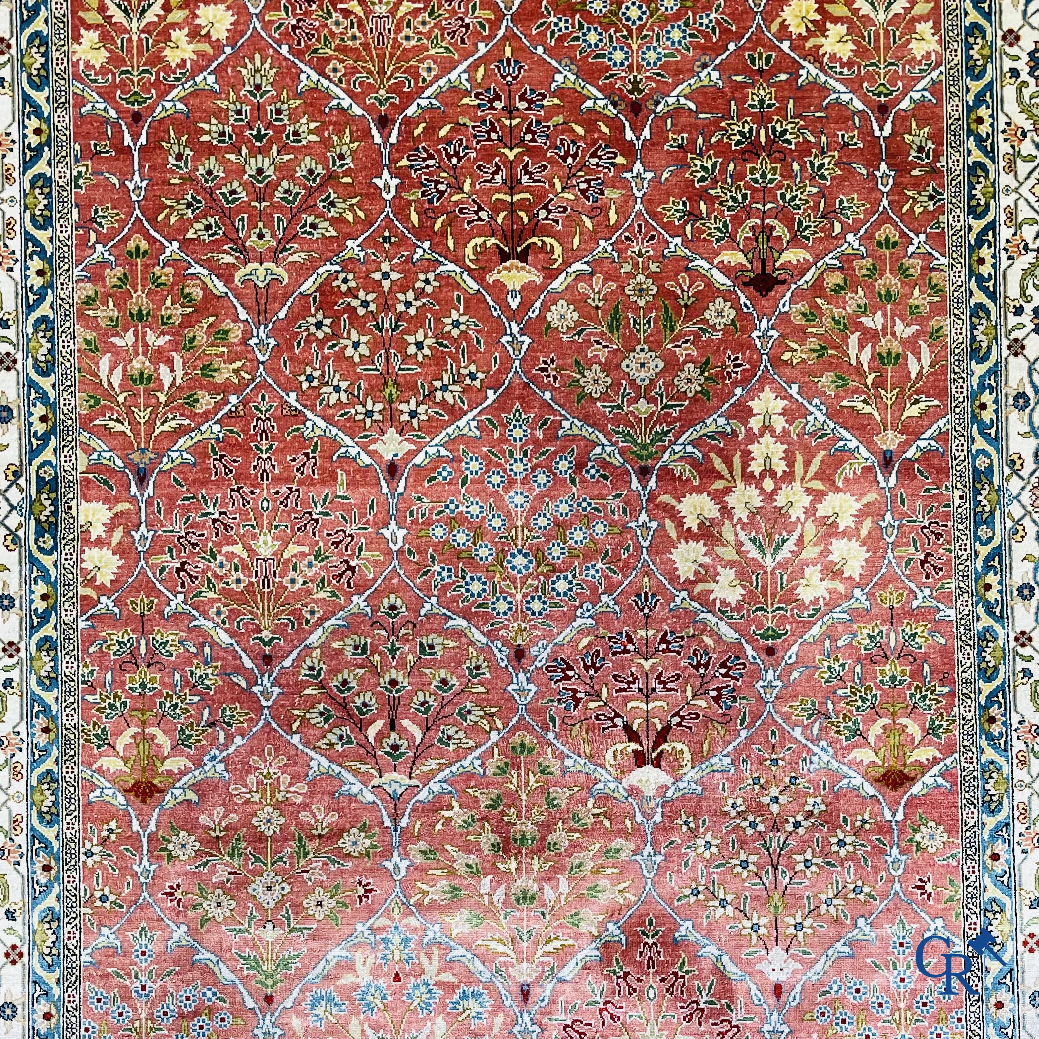 Tapis d'Orient: Un tapis finement noué à la main en laine et soie avec un décor floral.<br />
Signé.