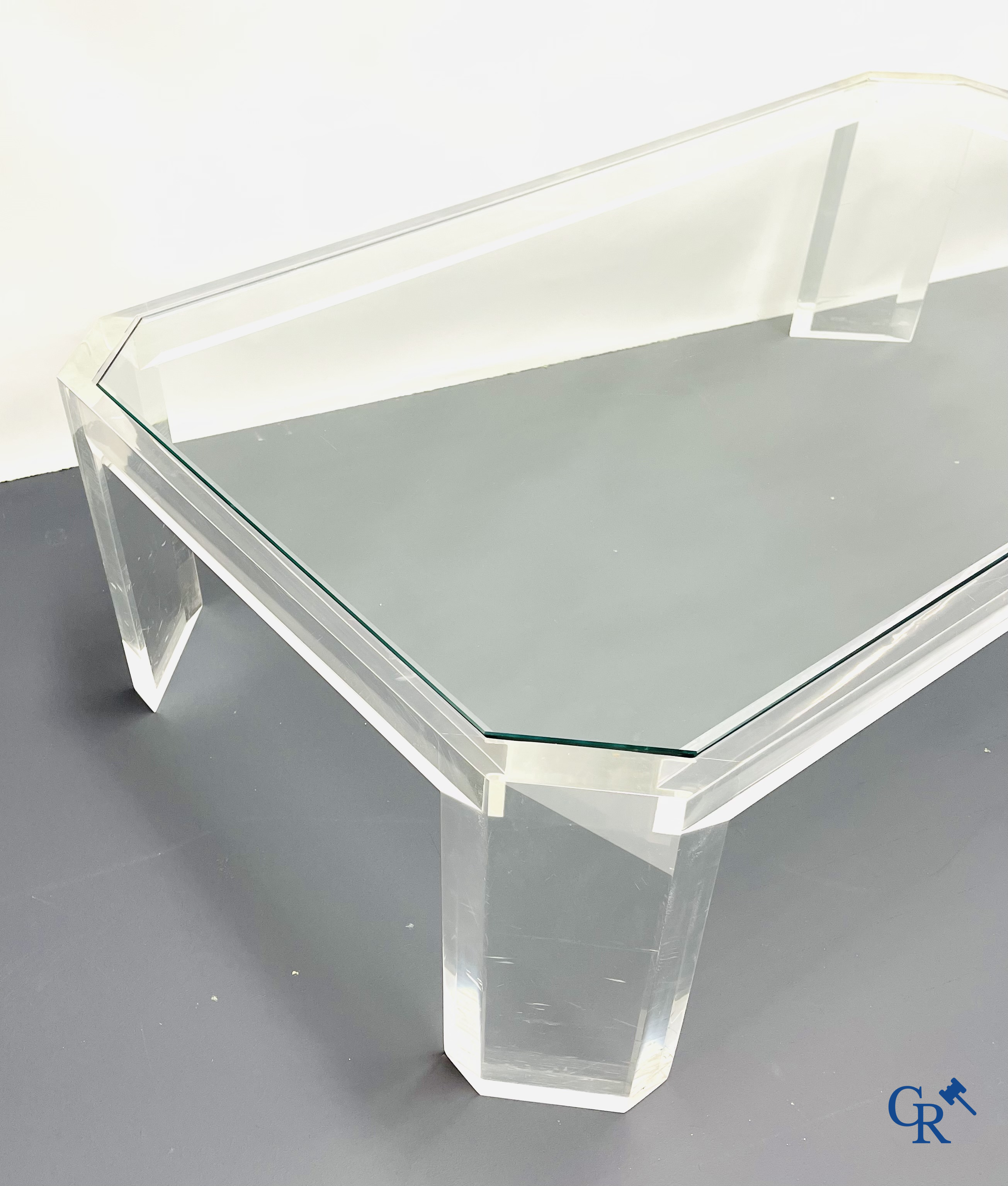 Une table basse en plexiglas avec une tablette en verre. Vers 1980.