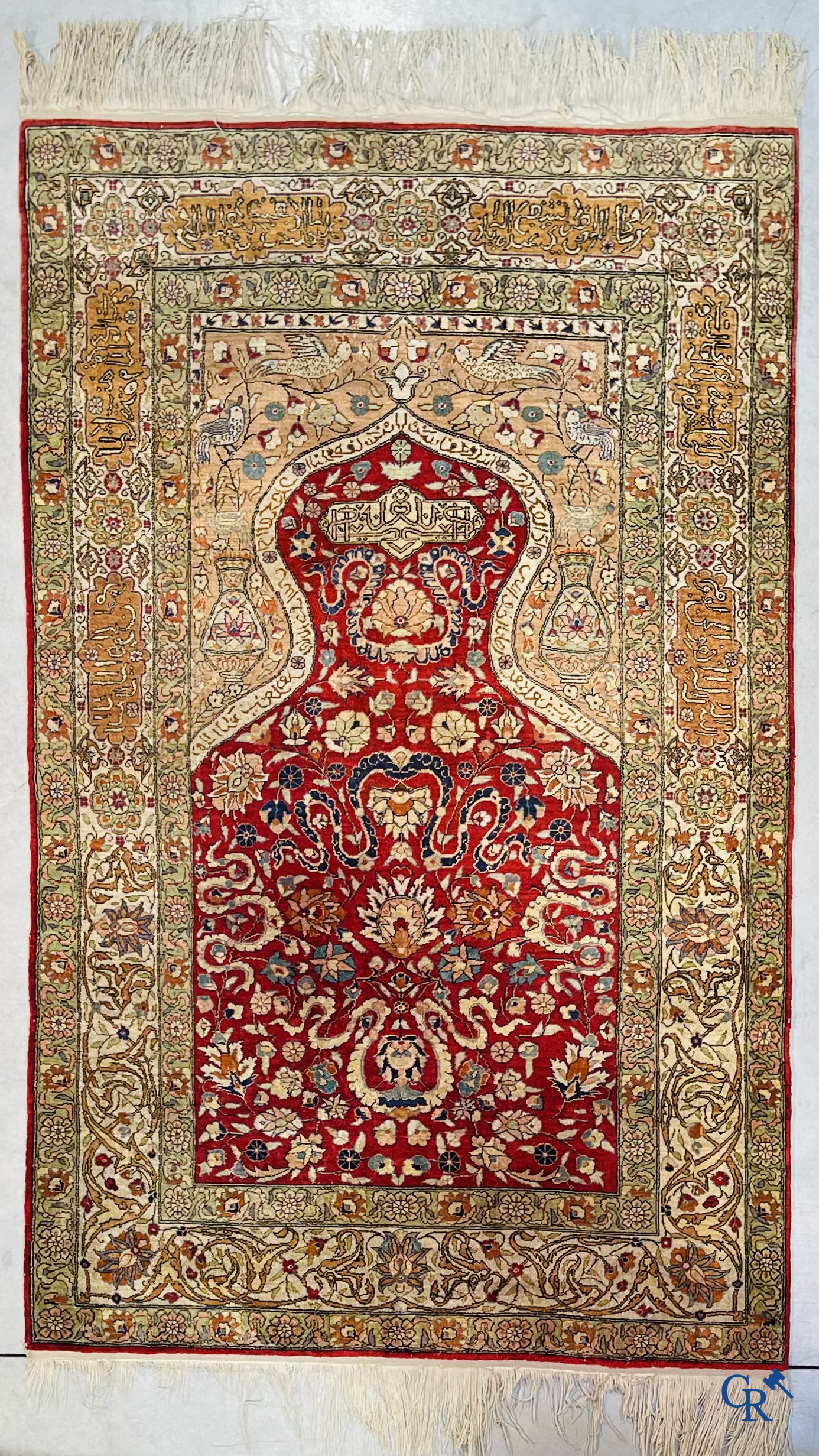 Oriental carpets: Hereke, a finely knotted silk carpet with inscriptions and birds in a floral decor.