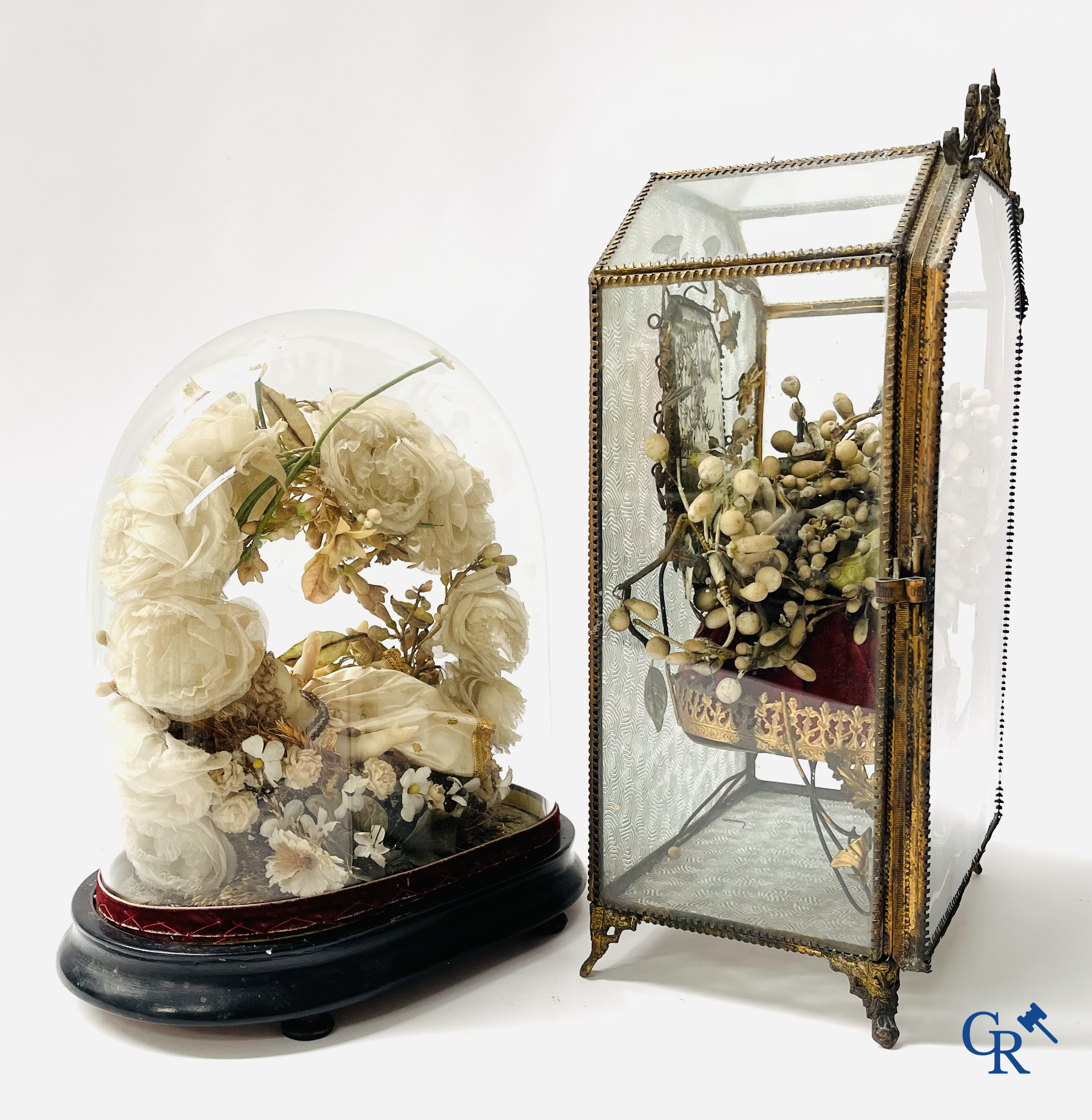 Un globe en verre avec un enfant en cire et une vitrine en laiton avec bouquet de mariée. Vers 1900.