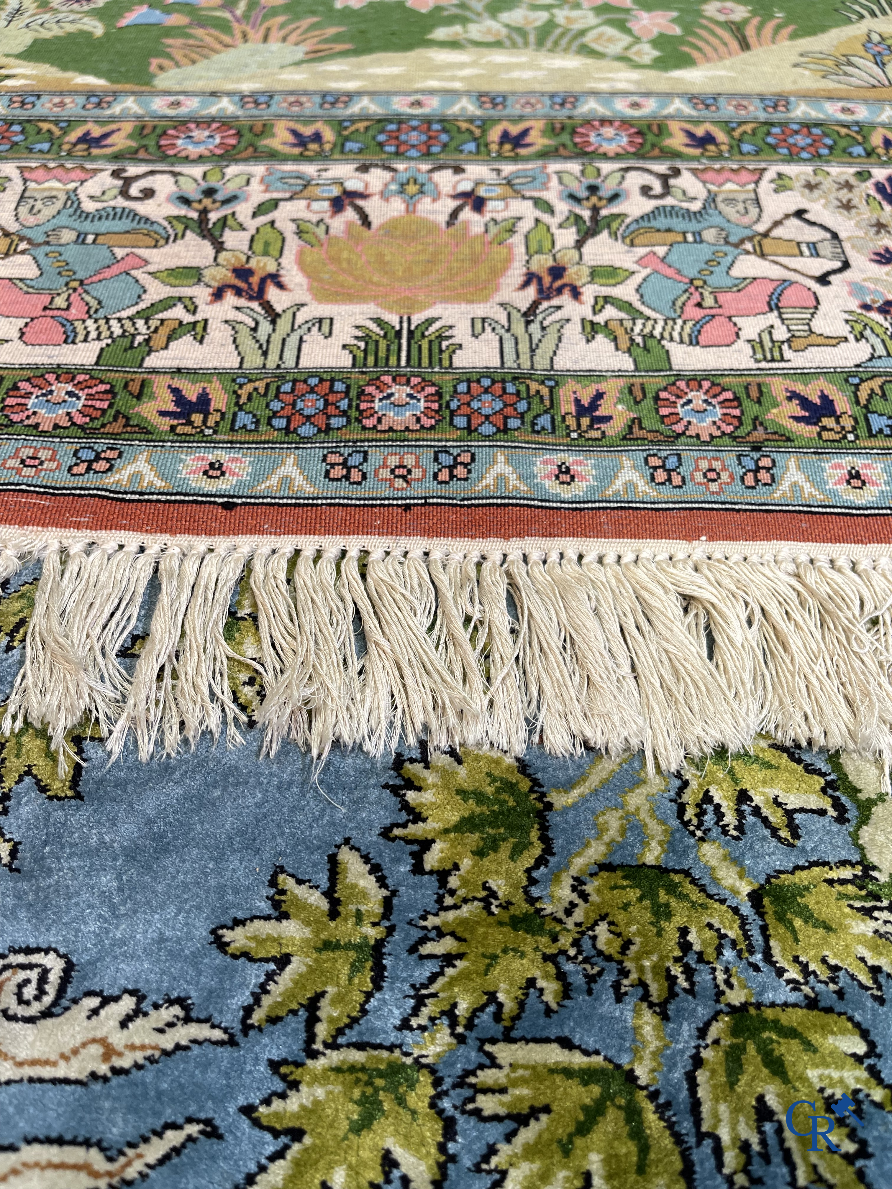 Tapis d'Orient. Iran. Un tapis persan en soie finement noué à la main avec des personnages et un cheval dans un paysage.