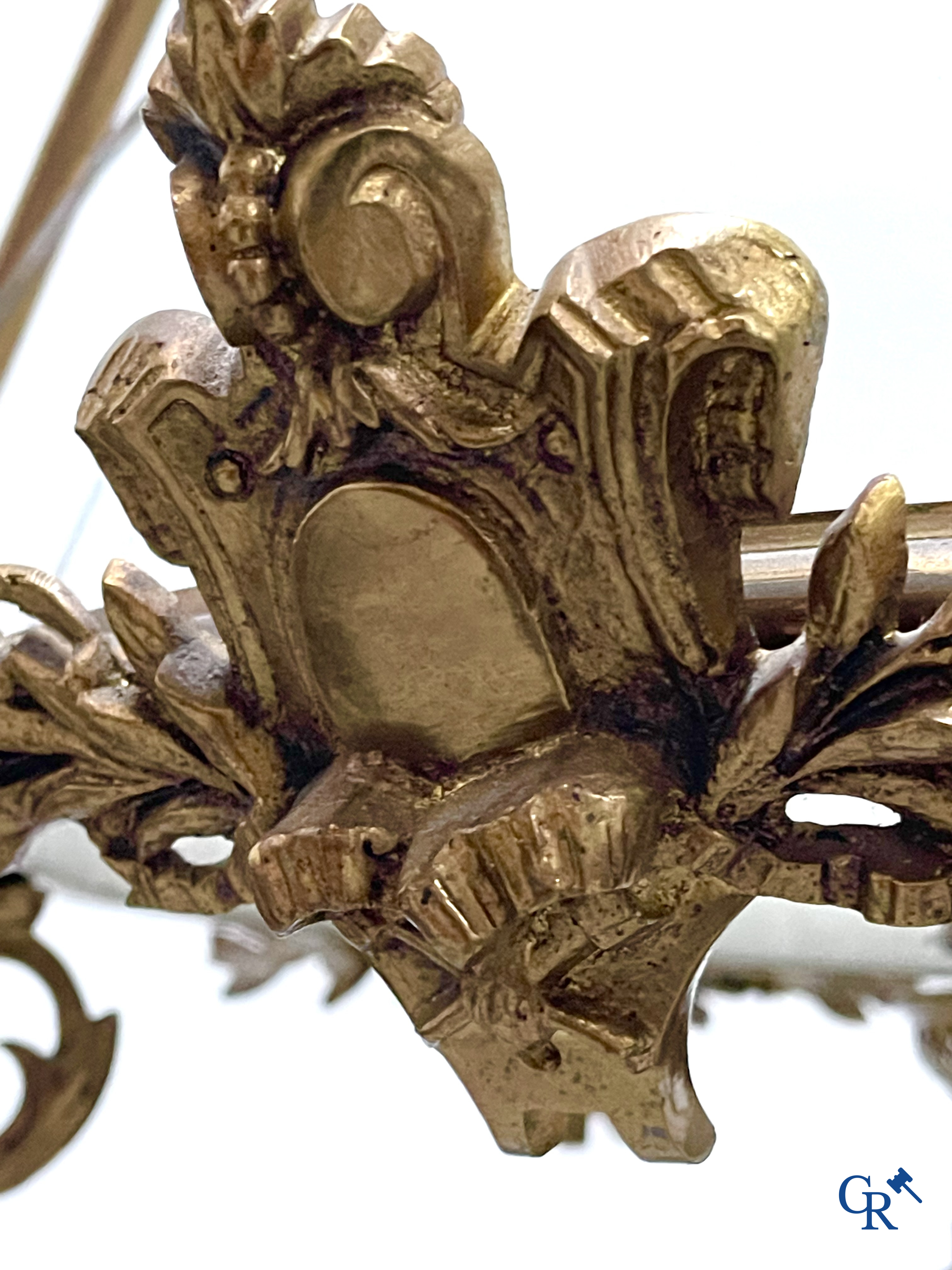 A lot of an imposing chandelier with 12 light points, a lamp belge with bronze frame and a fireplace piece.