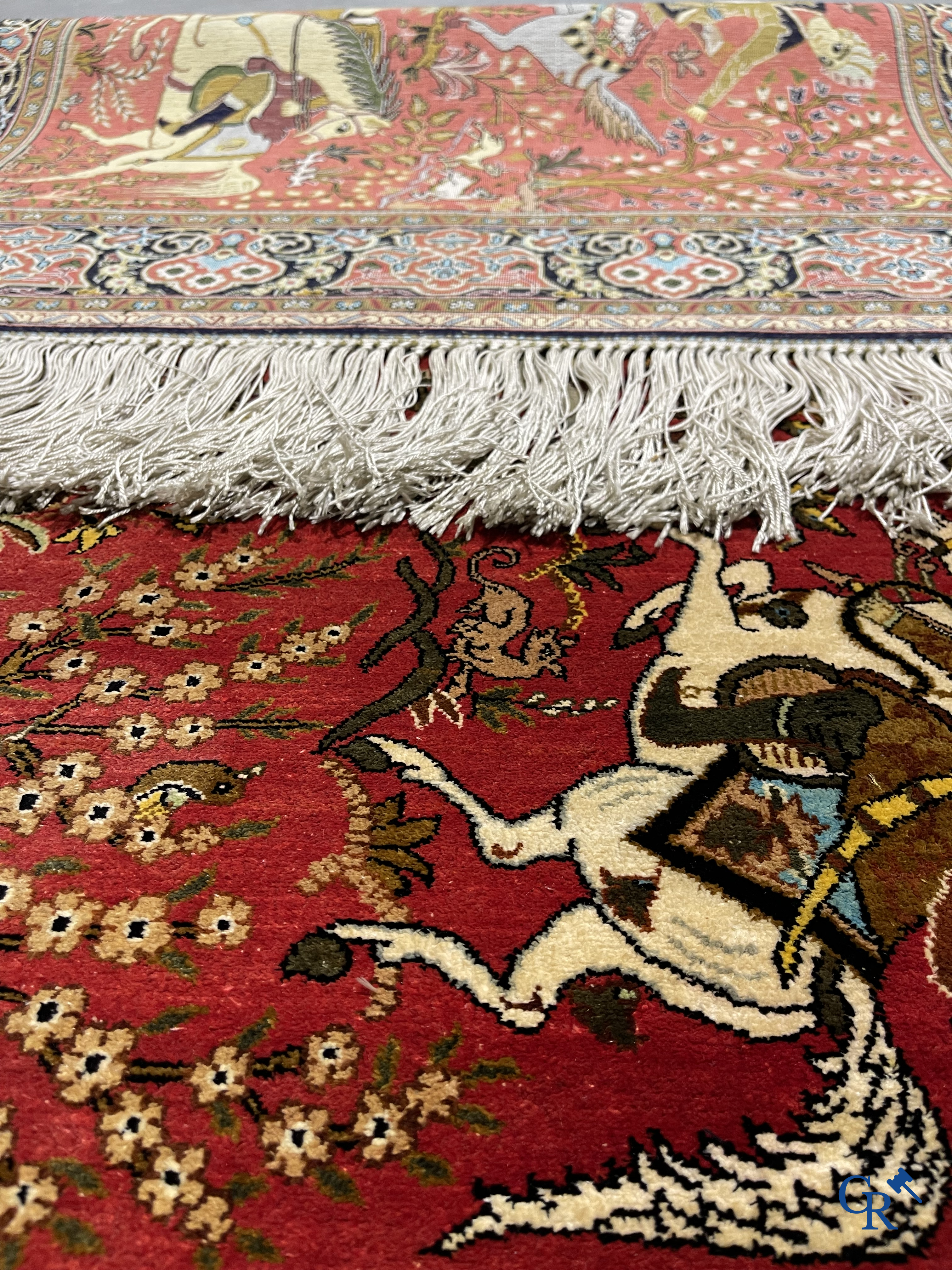 Oriental carpets, a Persian carpet in silk with a scene of hunters on horseback.