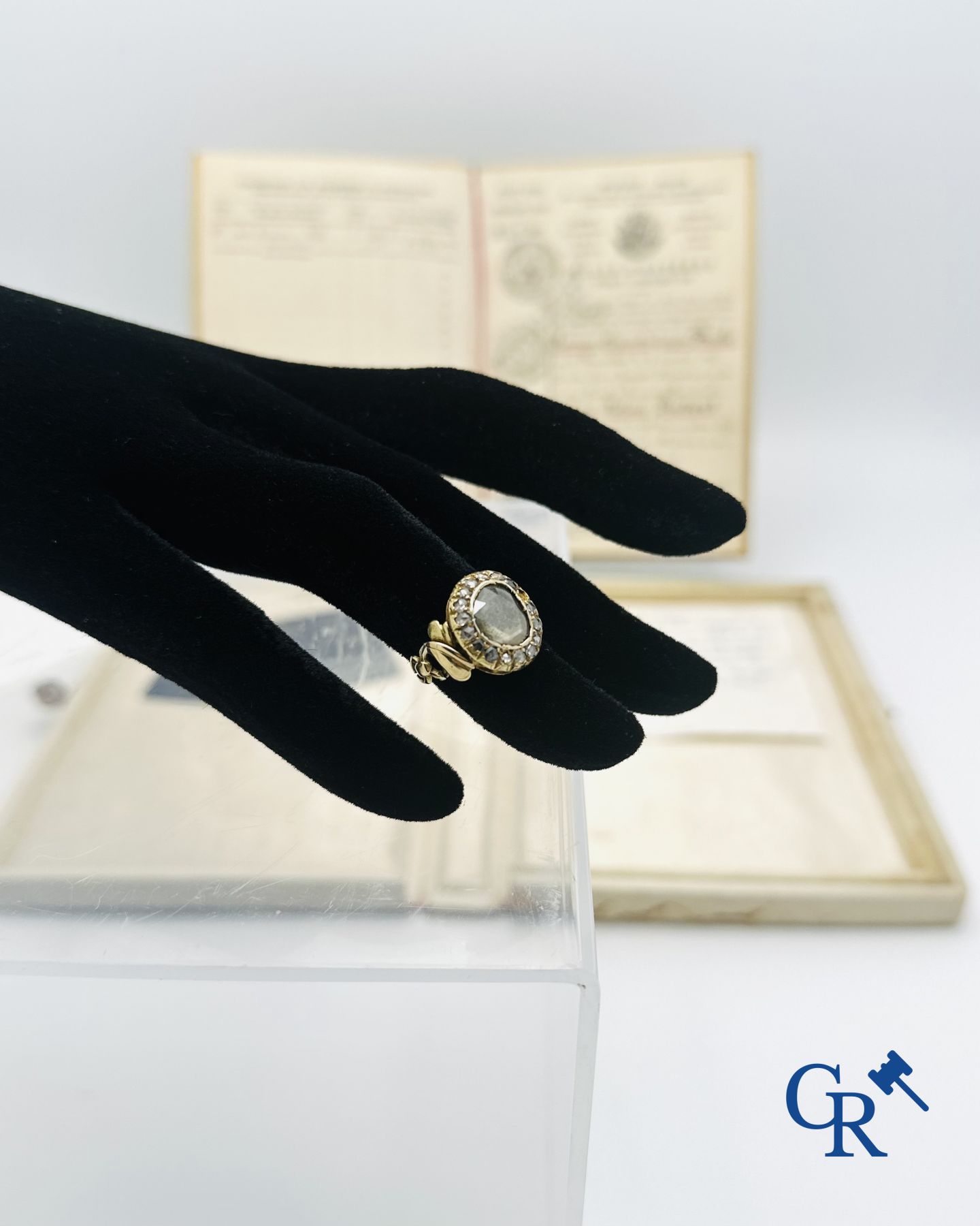 Juweel: Ring in goud 18K bezet met een grote diamant en 16 kleine diamantjes.