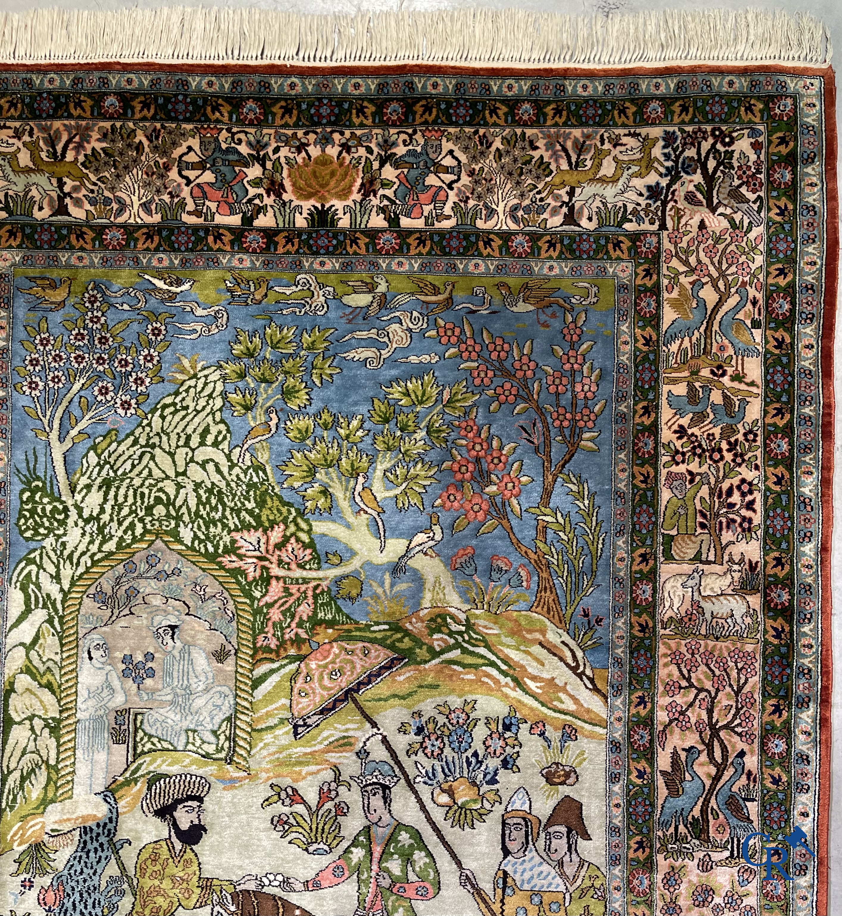 Tapis d'Orient. Iran. Un tapis persan en soie finement noué à la main avec des personnages et un cheval dans un paysage.