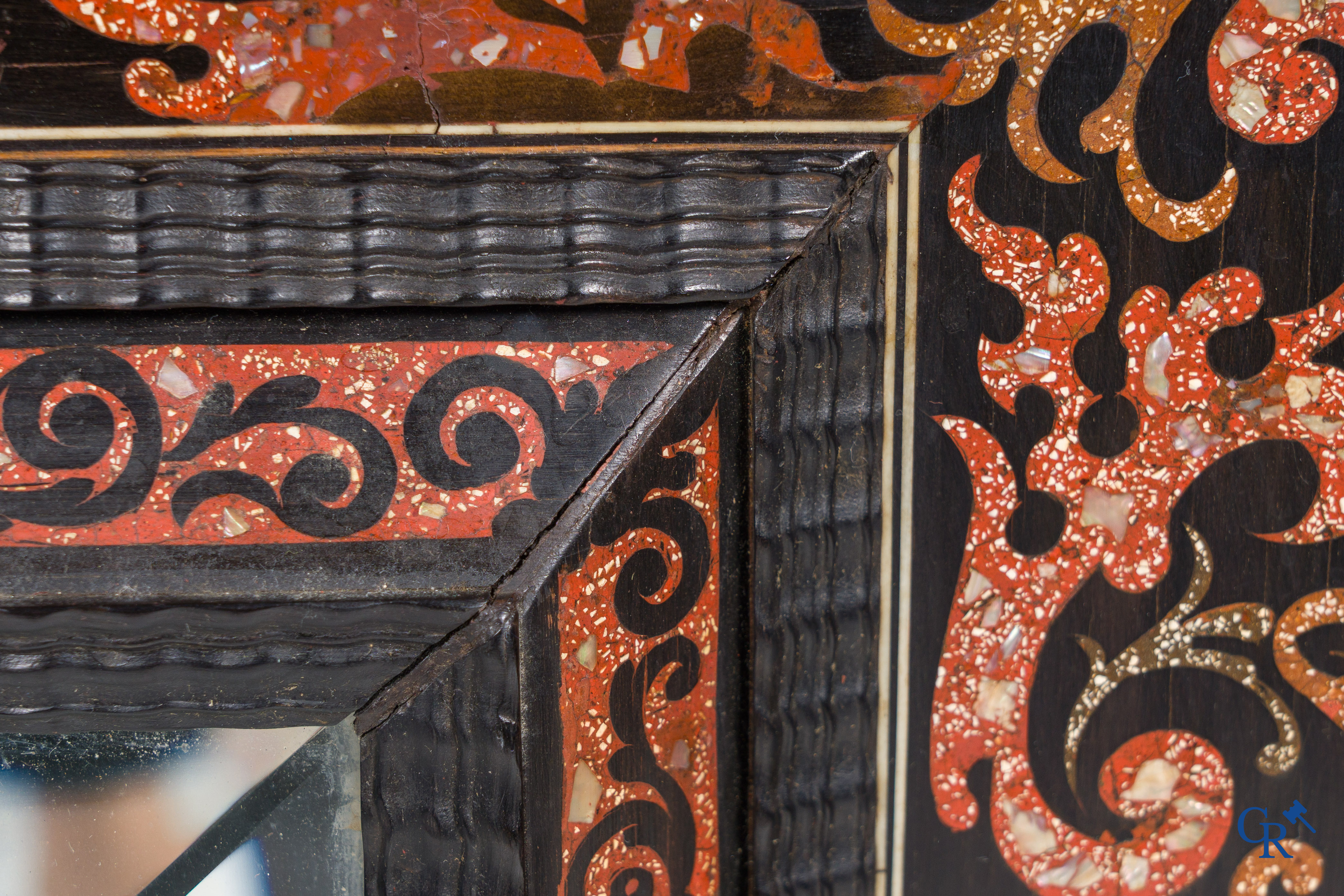 Een spiegel in ebbenhout en inlegwerk. 18e- 19e eeuw.