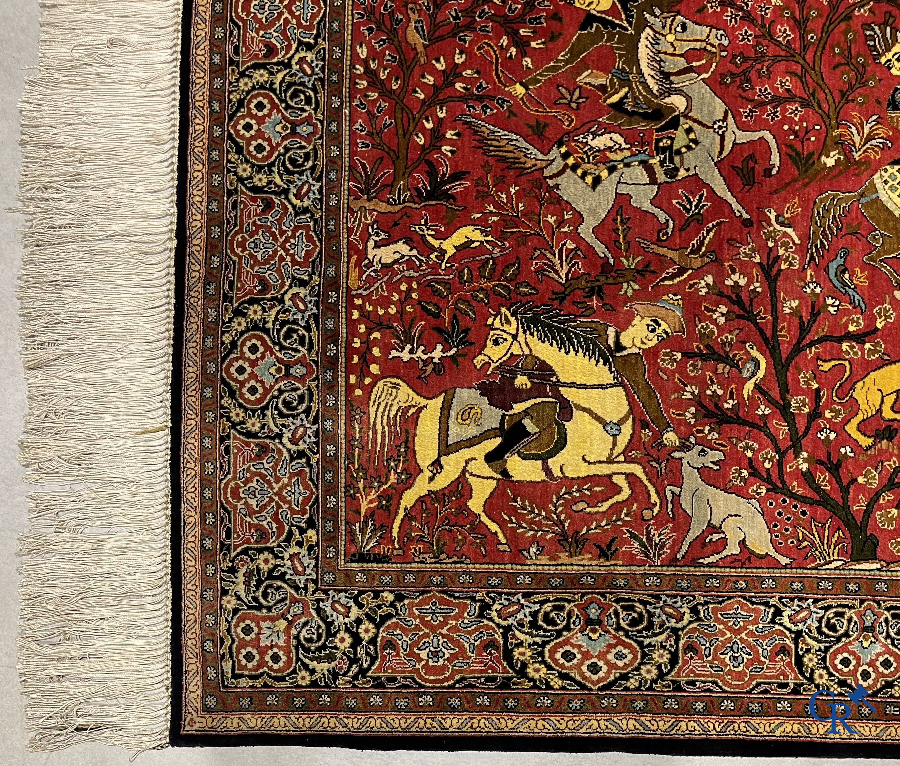 Oriental carpets, a Persian carpet in silk with a scene of hunters on horseback.