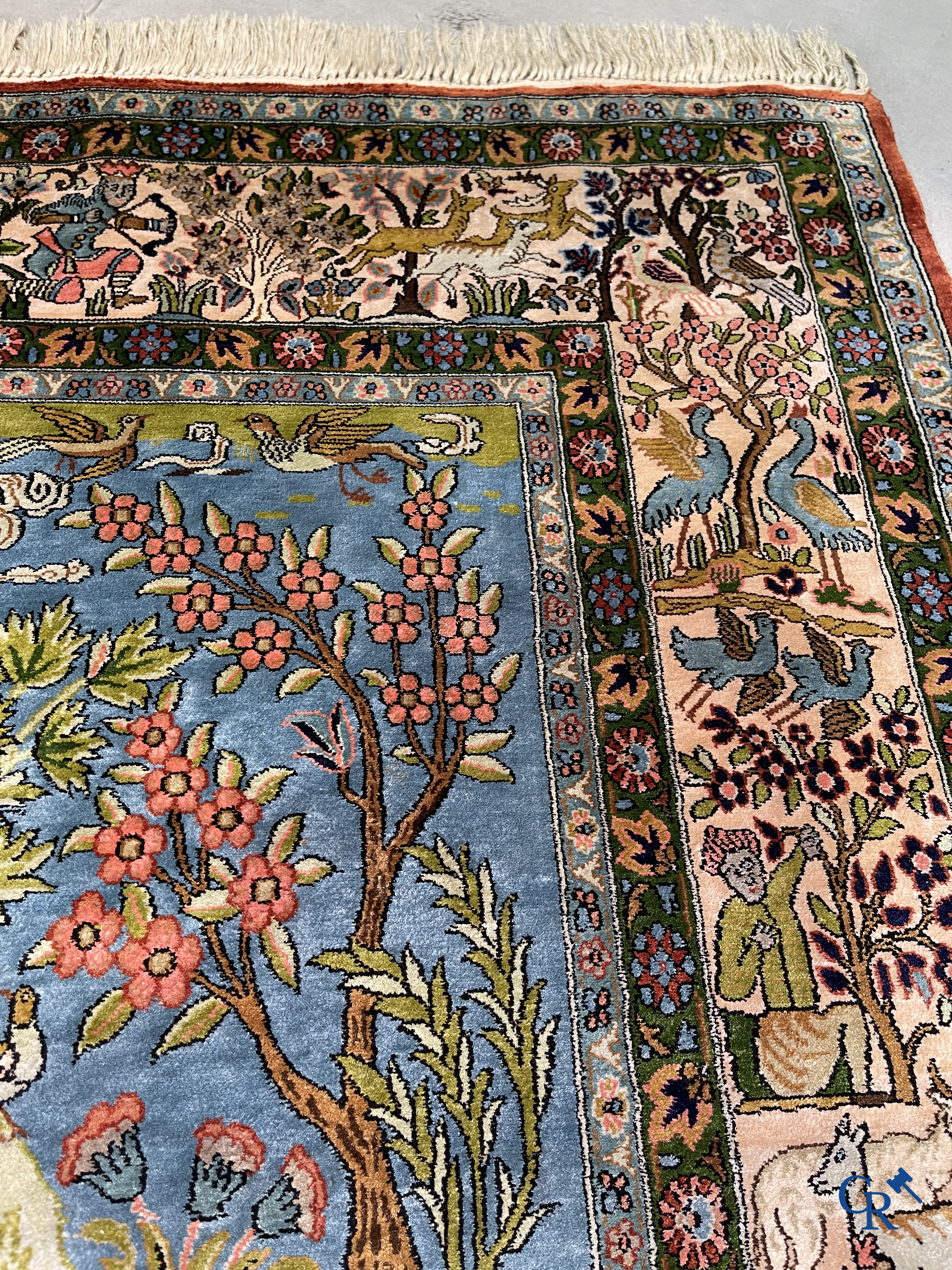 Tapis d'Orient. Iran. Un tapis persan en soie finement noué à la main avec des personnages et un cheval dans un paysage.