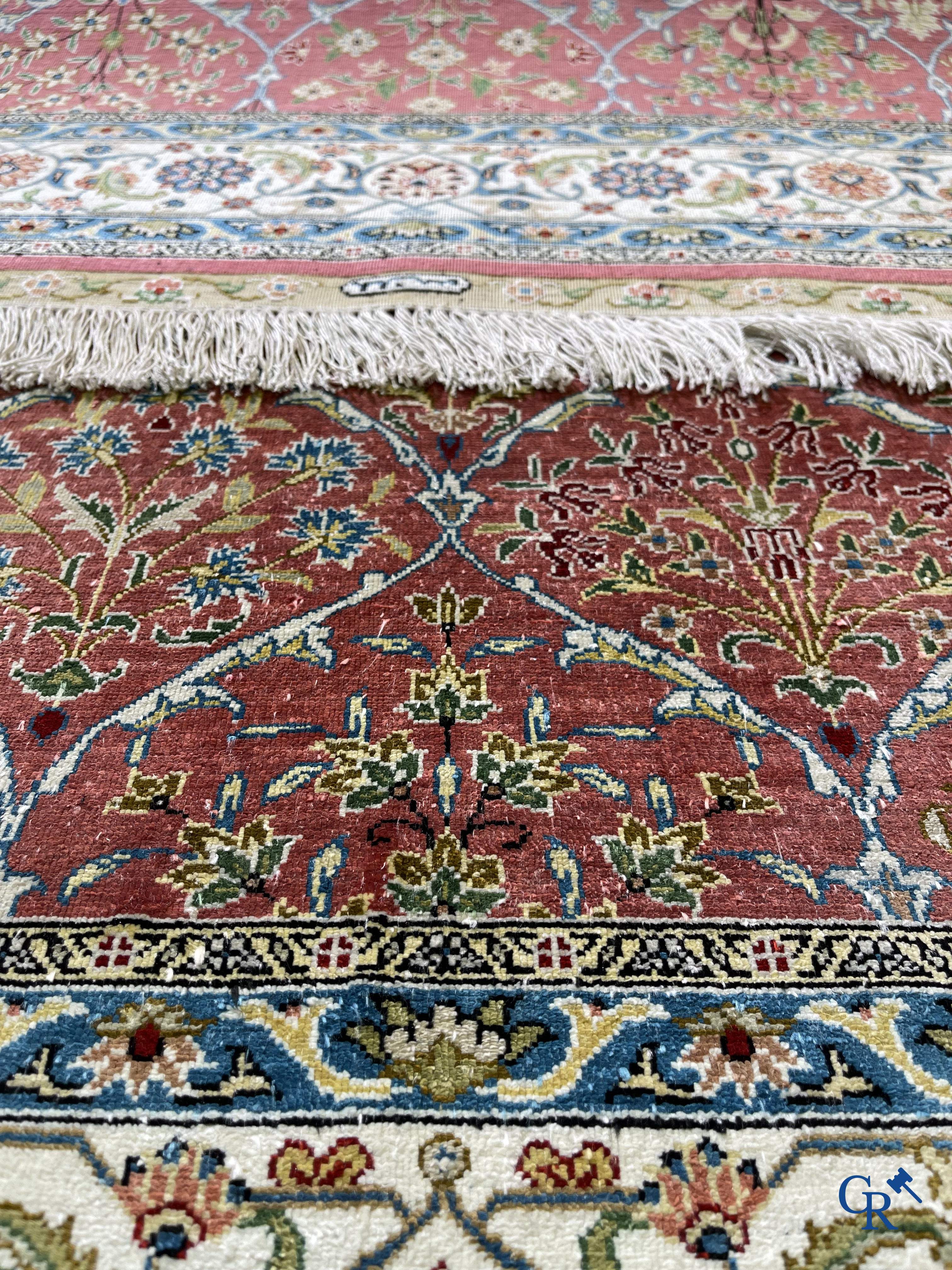 Tapis d'Orient: Un tapis finement noué à la main en laine et soie avec un décor floral.<br />
Signé.