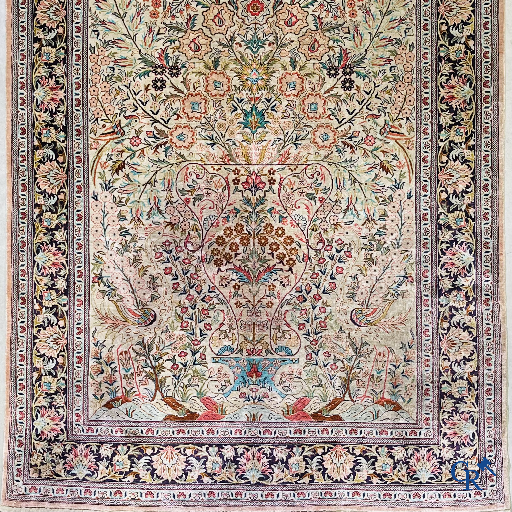 Tapis d'Orient: Un tapis persan en soie finement noué à la main avec un vase à fleurs et des oiseaux dans un décor floral.