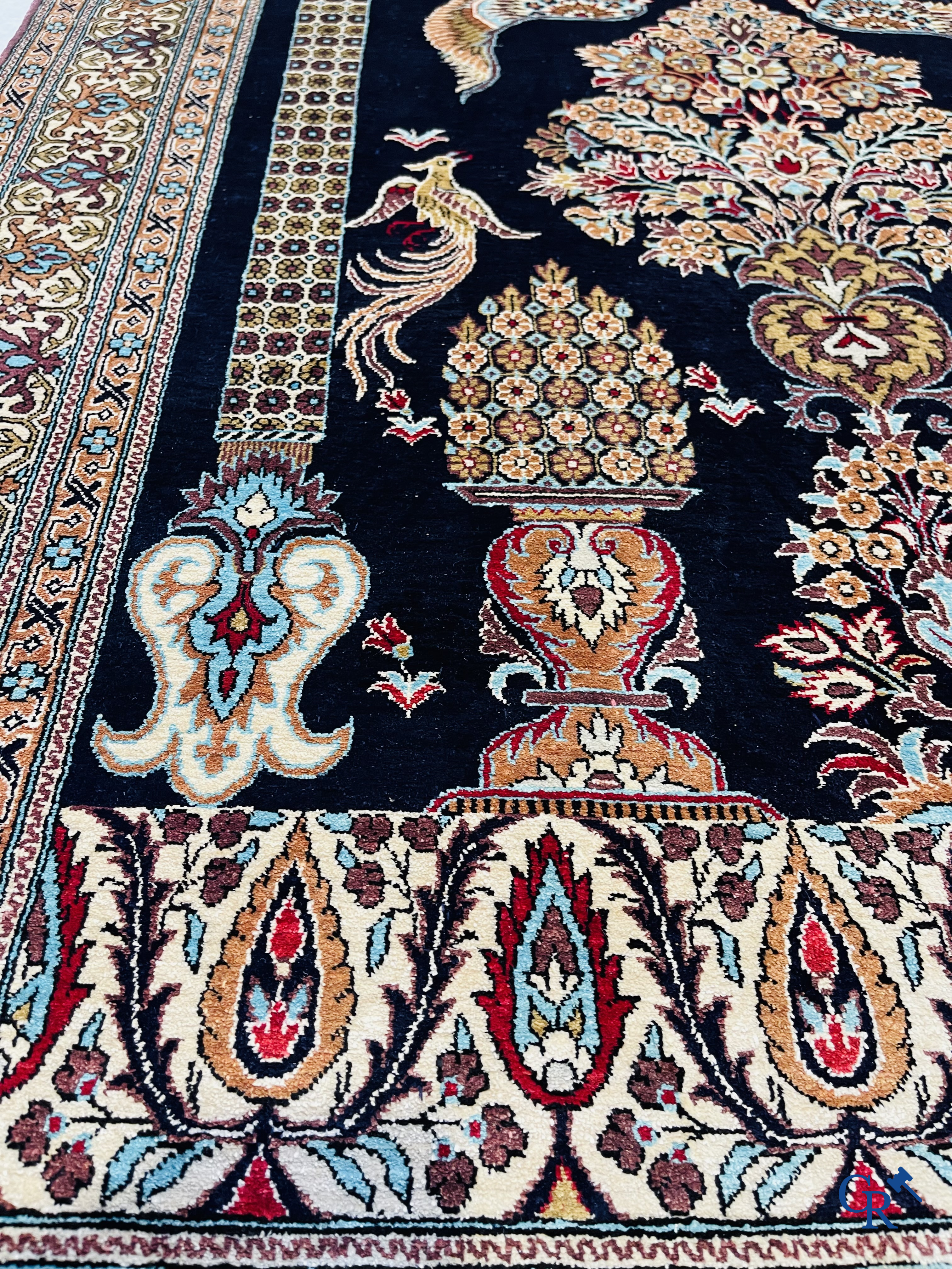 Persian carpets: A finely knotted silk Ghoum carpet with a decor of birds and flowers.