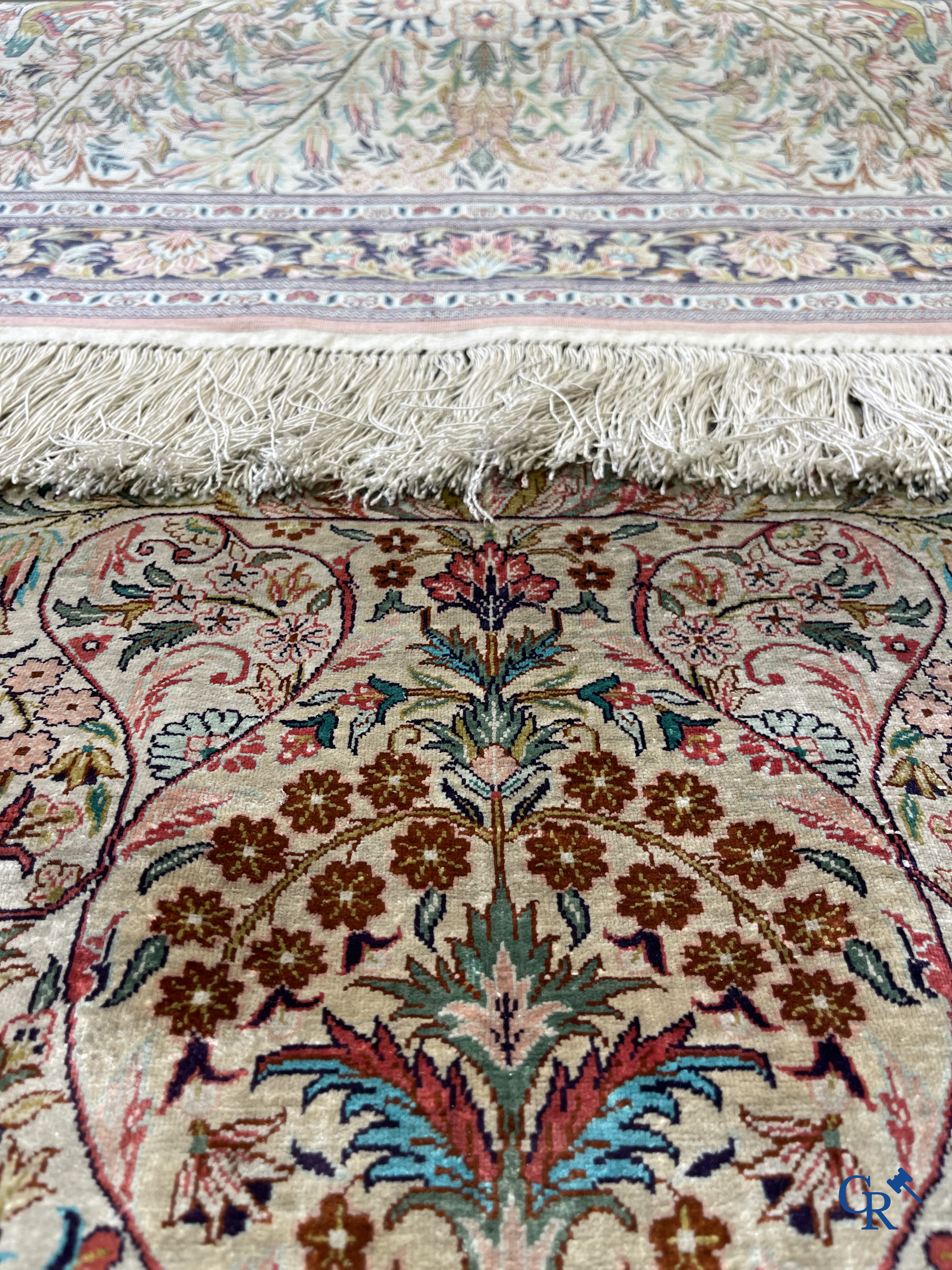 Tapis d'Orient: Un tapis persan en soie finement noué à la main avec un vase à fleurs et des oiseaux dans un décor floral.