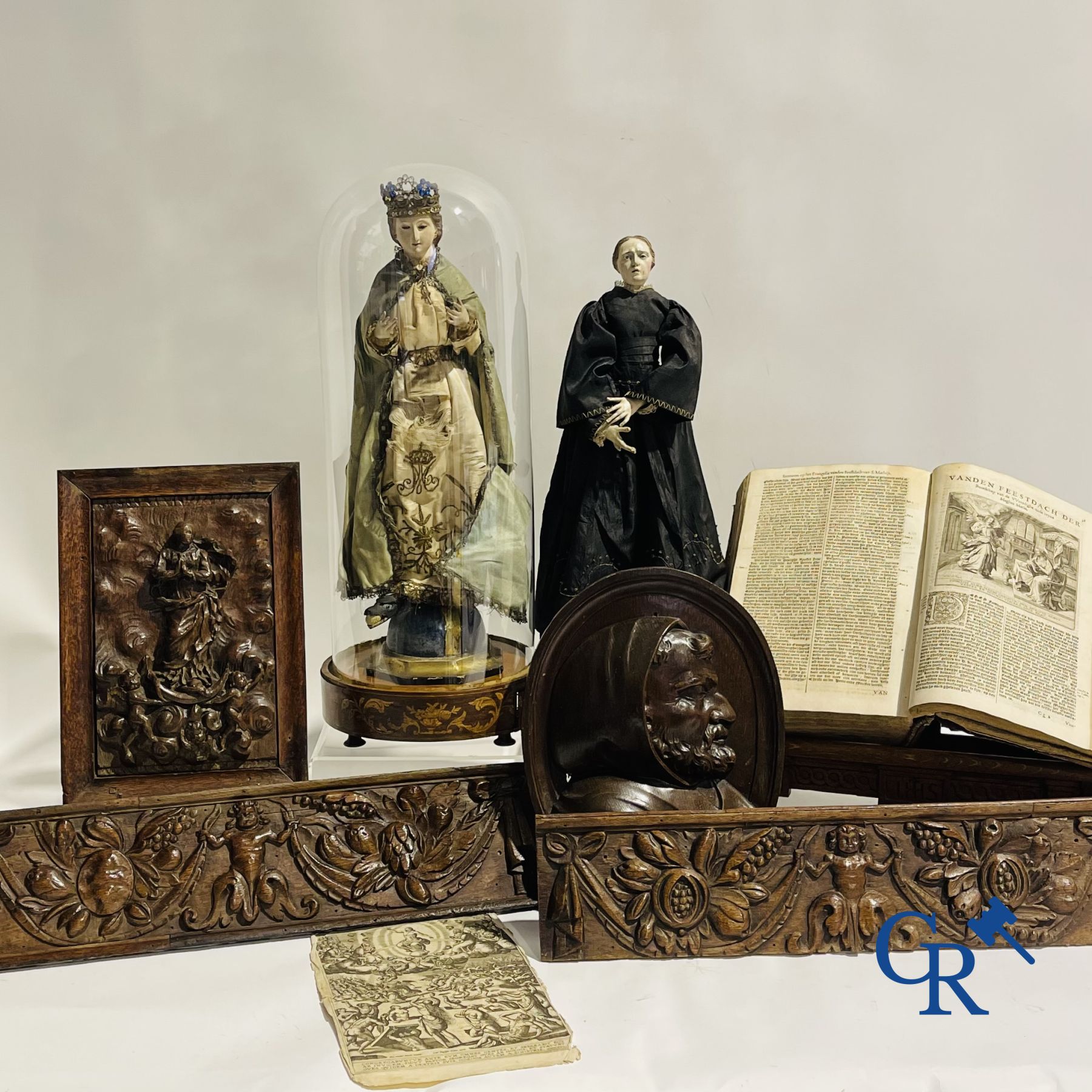 Un lot avec diverses sculptures antiques en bois et un livre antique sur une table de lecture.