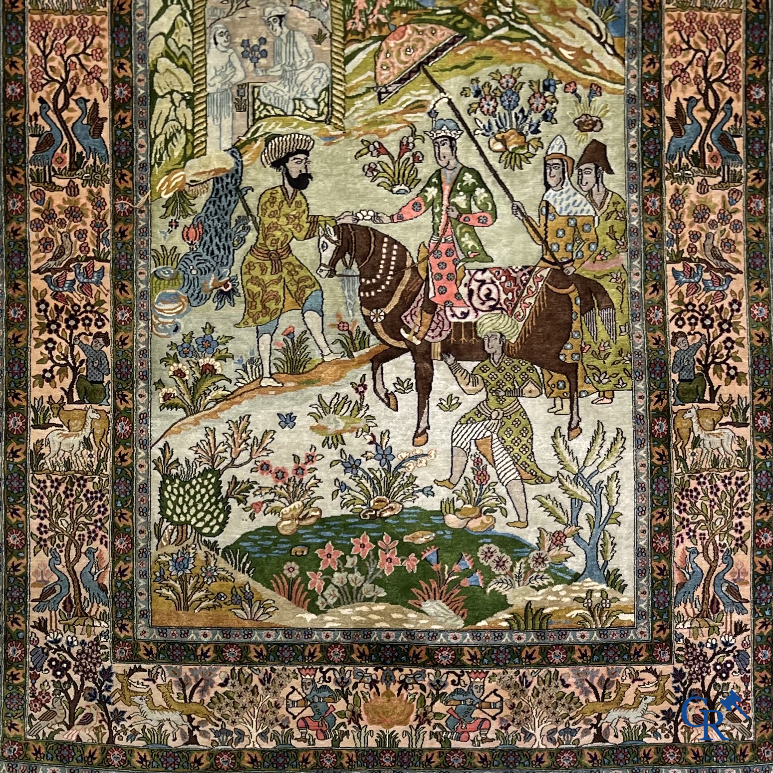 Tapis d'Orient. Iran. Un tapis persan en soie finement noué à la main avec des personnages et un cheval dans un paysage.