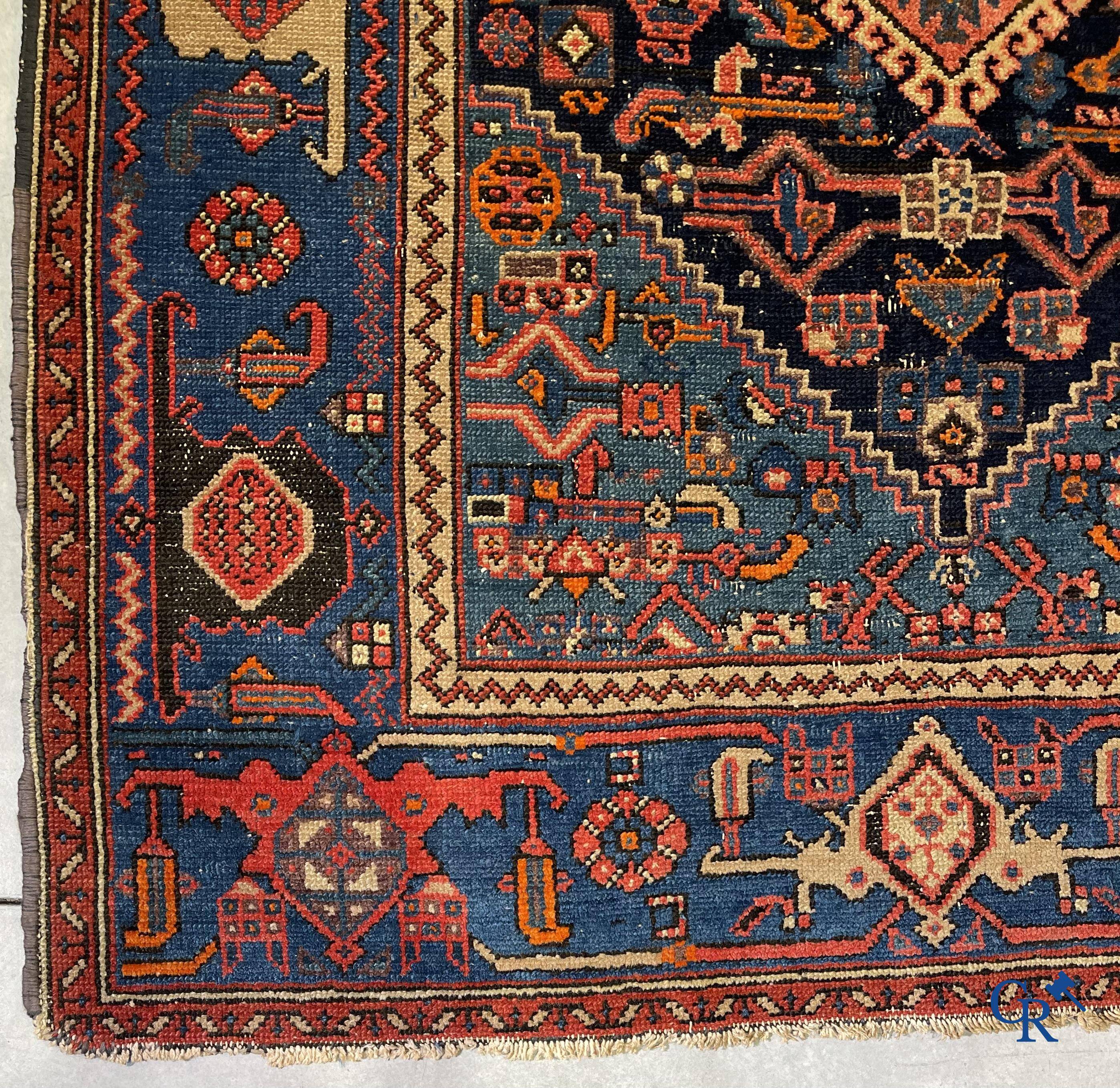 Antique Oriental carpets, an antique hand-knotted carpet with motifs on a blue background.