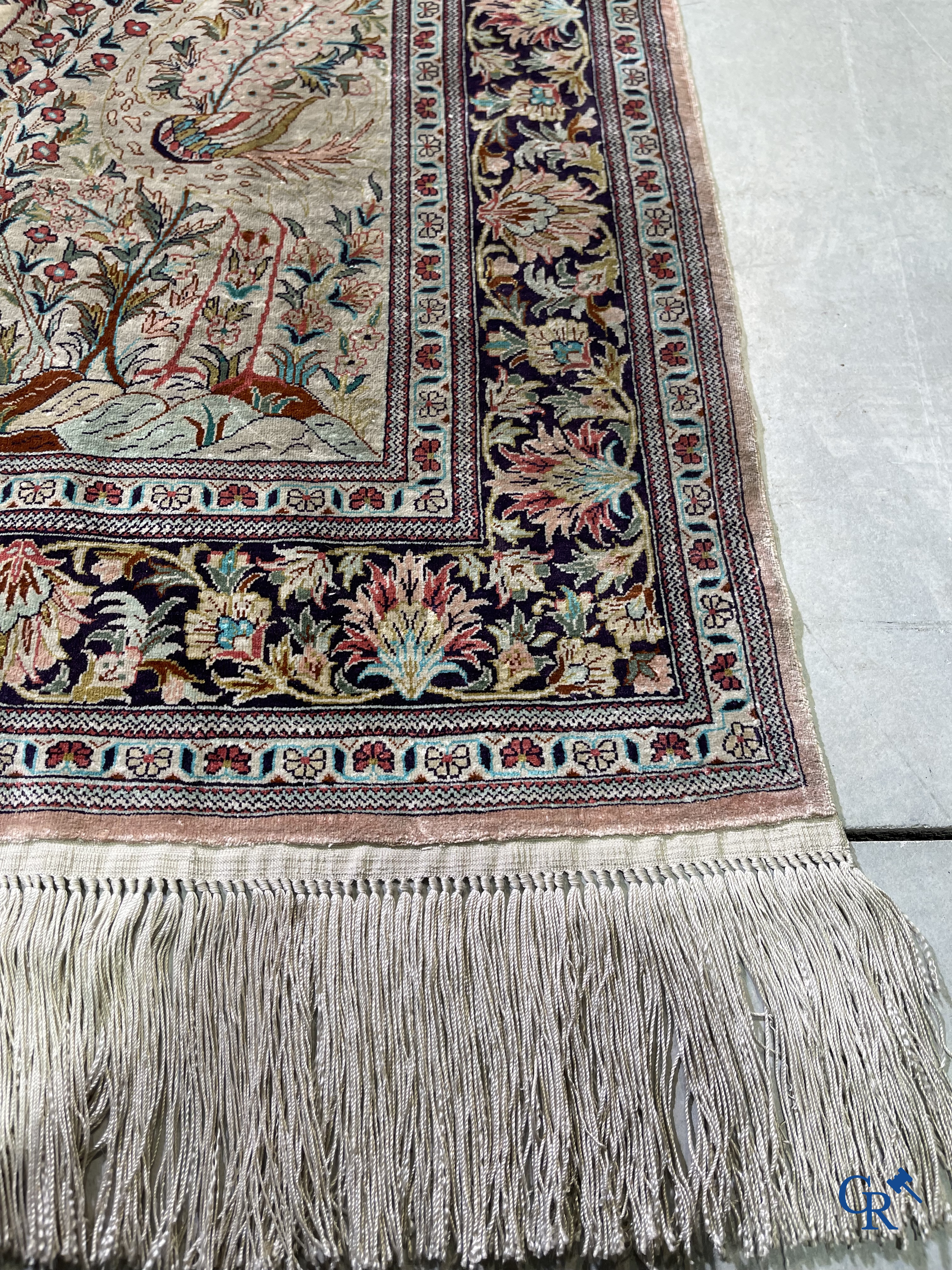 Tapis d'Orient: Un tapis persan en soie finement noué à la main avec un vase à fleurs et des oiseaux dans un décor floral.