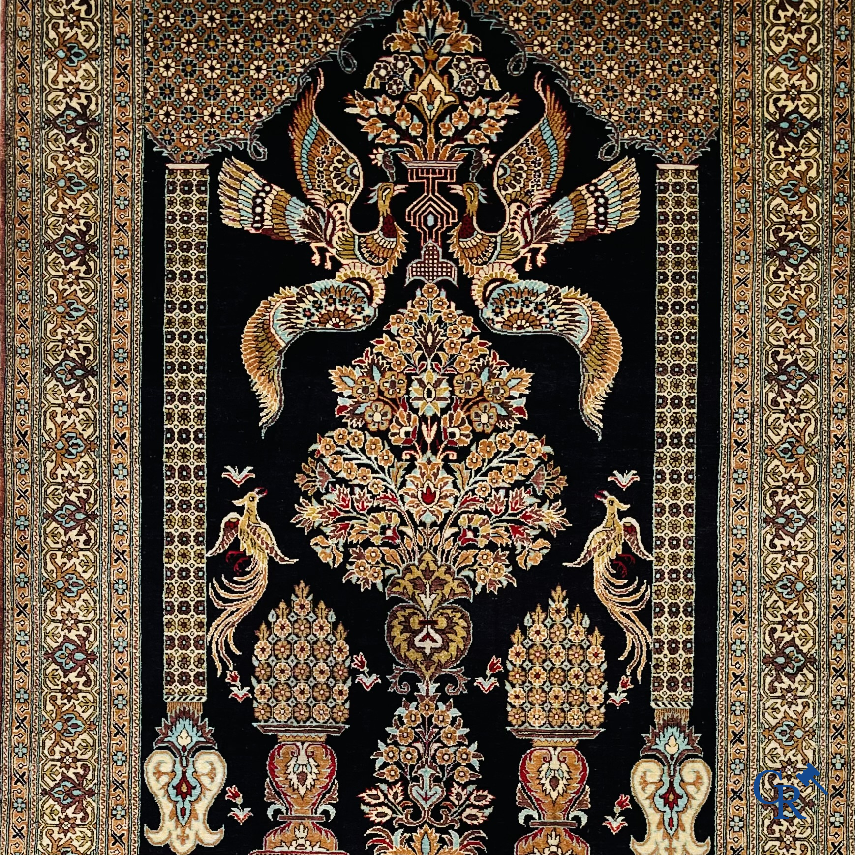 Persian carpets: A finely knotted silk Ghoum carpet with a decor of birds and flowers.