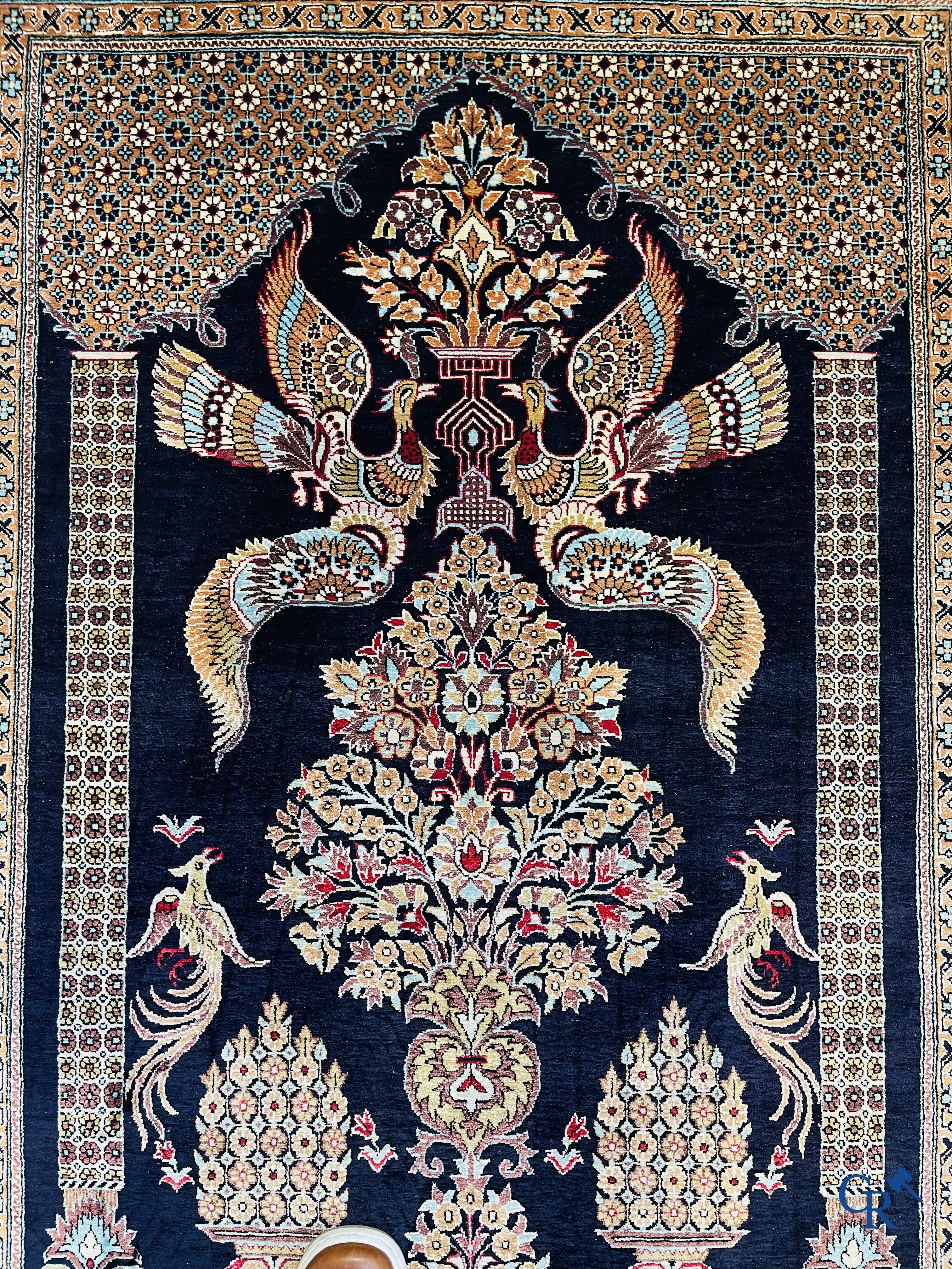 Persian carpets: A finely knotted silk Ghoum carpet with a decor of birds and flowers.