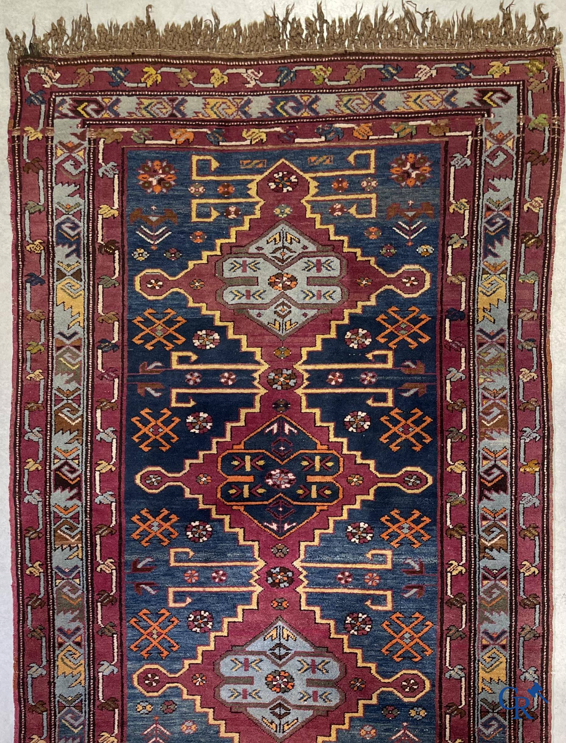 Oriental carpets, an antique hand-knotted Oriental carpet with motifs on a blue background.