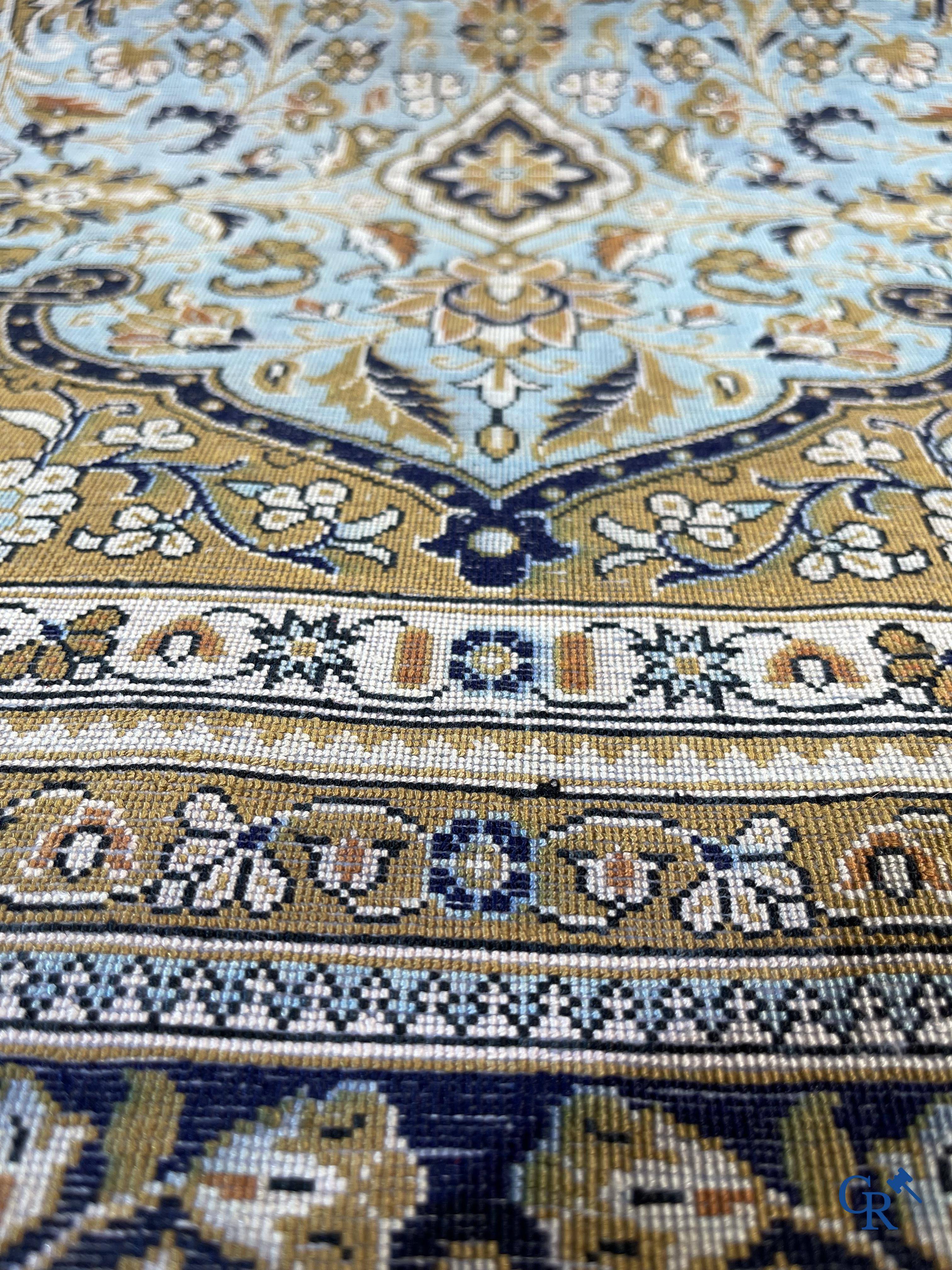 Tapis d'Orient. Un tapis en soie finement noué à la main avec un décor floral.