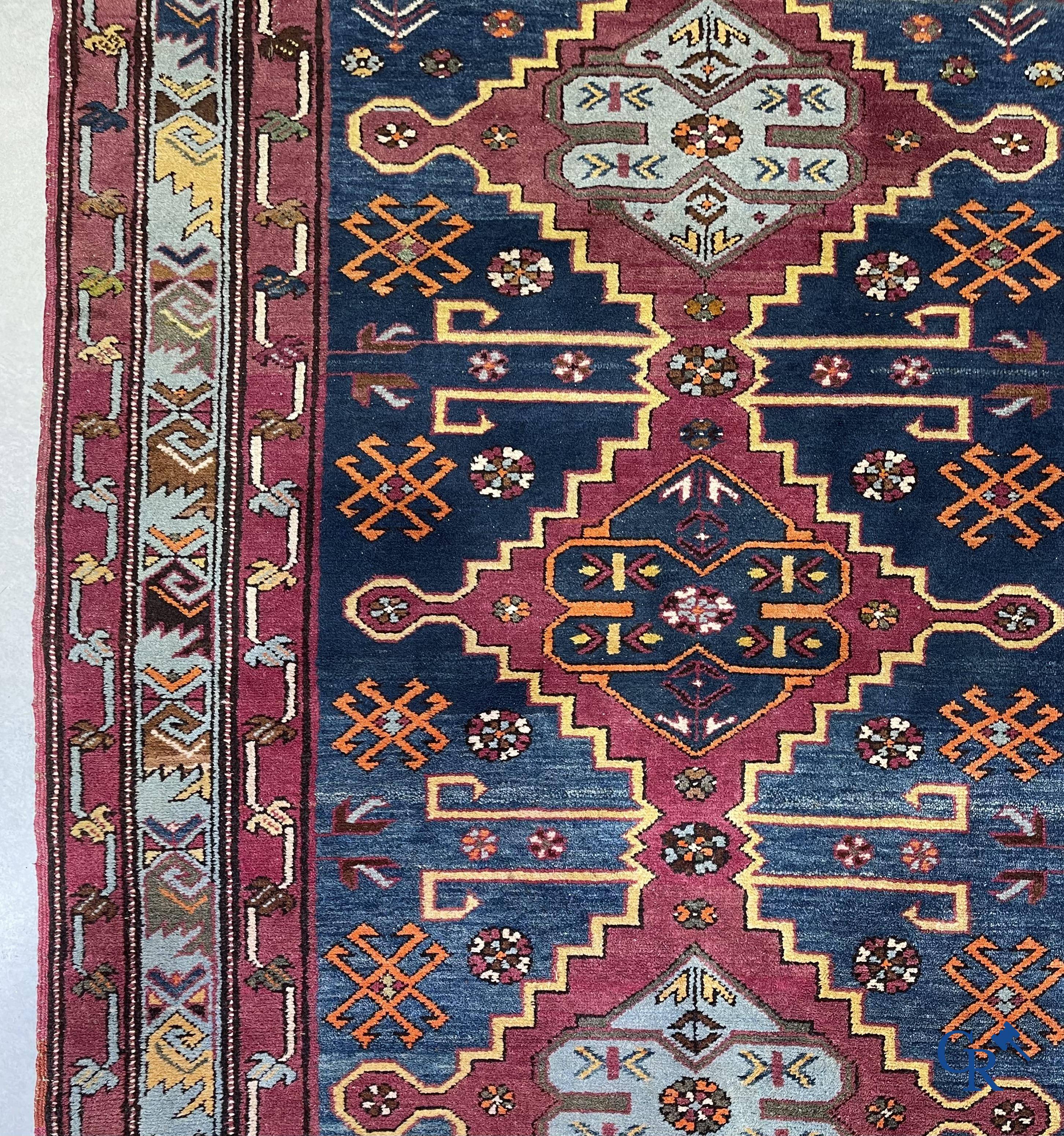 Oriental carpets, an antique hand-knotted Oriental carpet with motifs on a blue background.