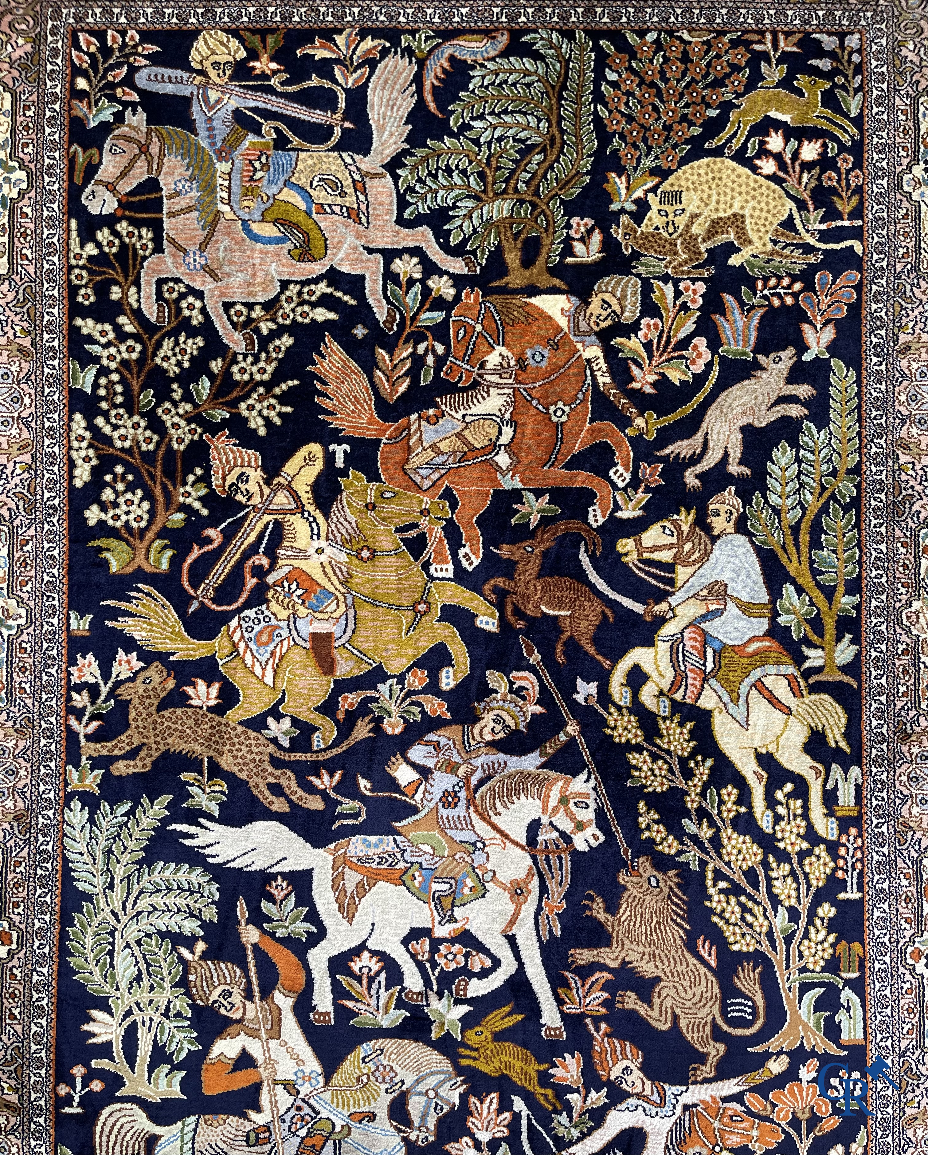 Oriental rugs. Iran. A finely hand-knotted Persian rug in wool and silk with hunters on horseback and inscriptions.