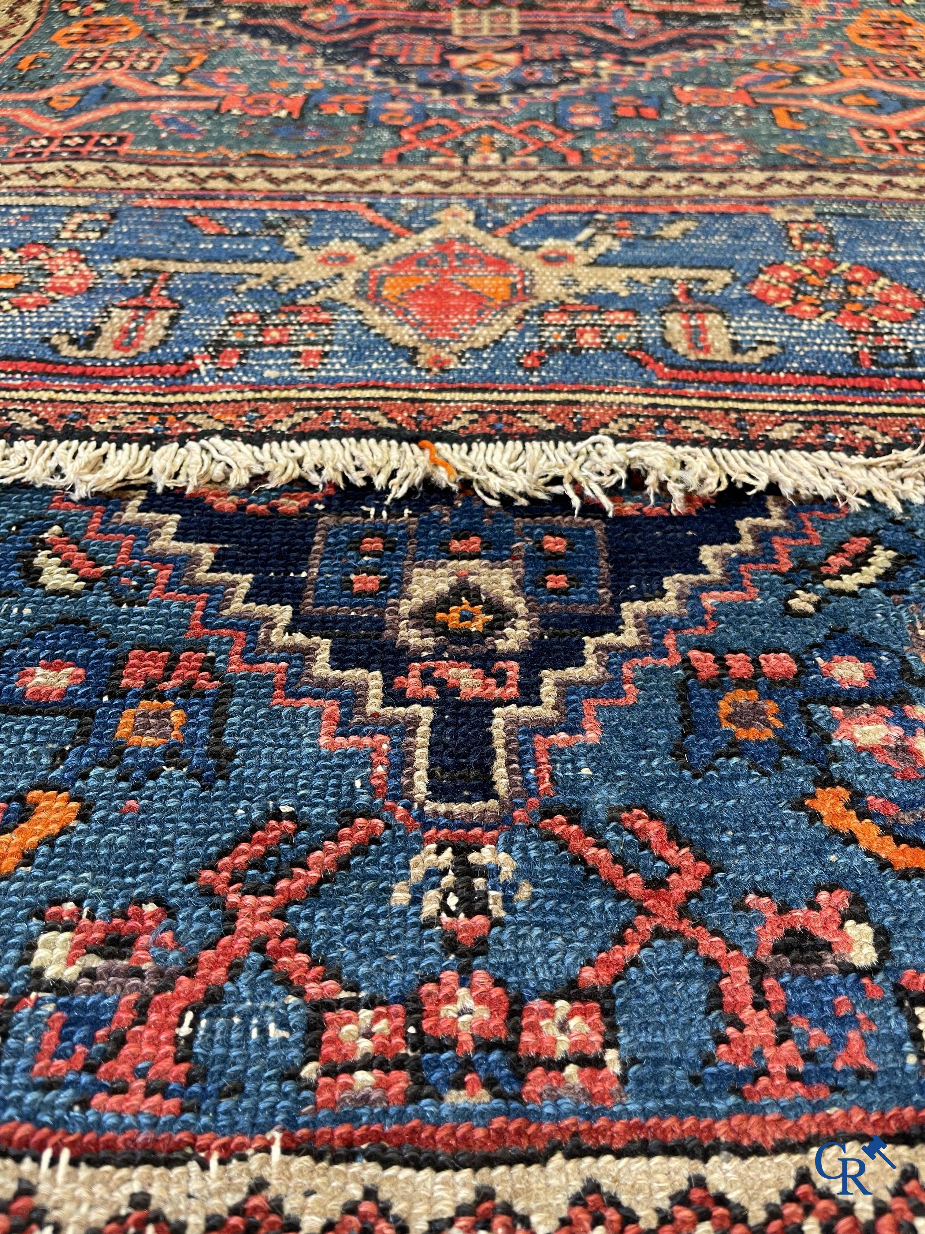 Antique Oriental carpets, an antique hand-knotted carpet with motifs on a blue background.