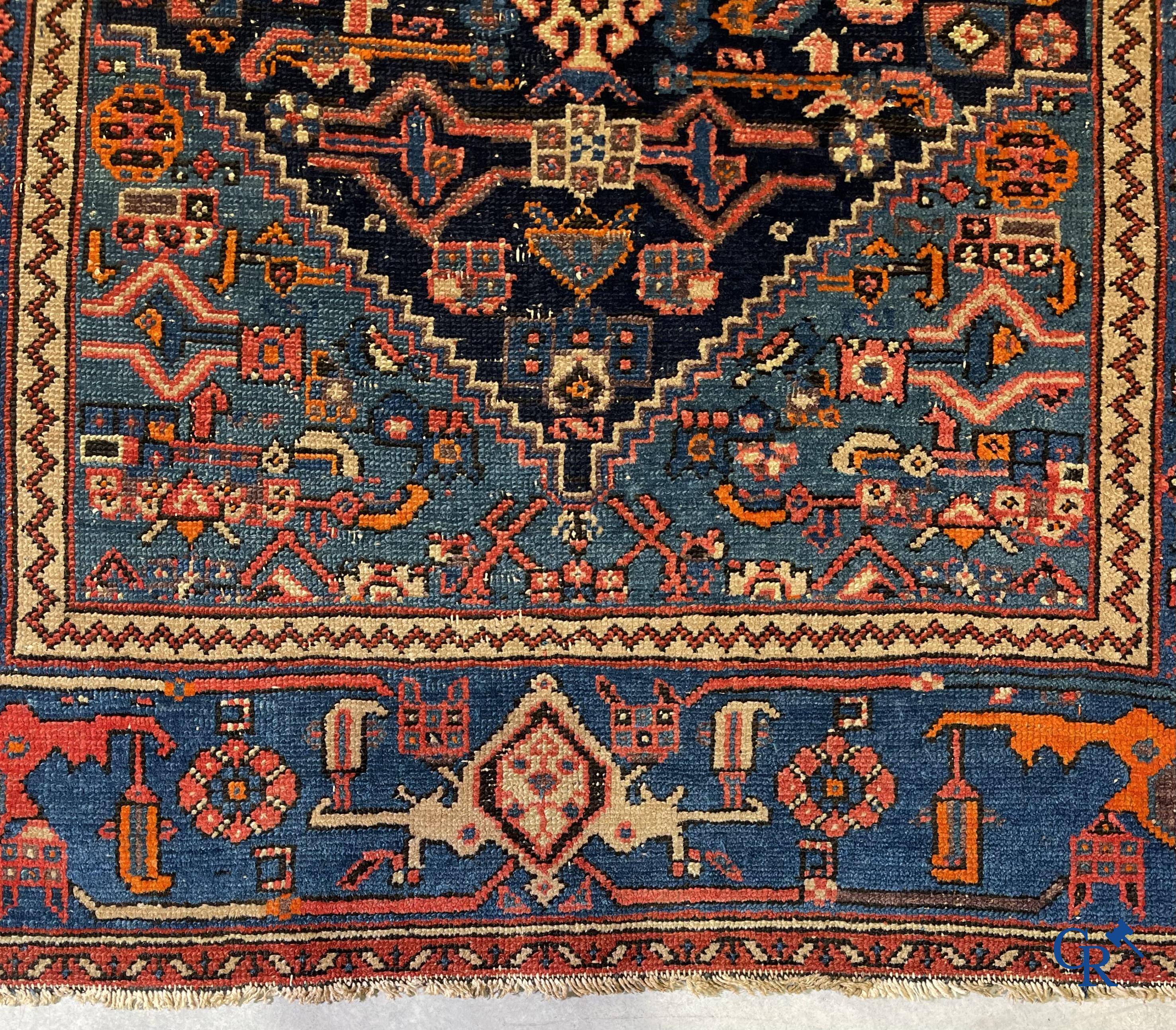 Antique Oriental carpets, an antique hand-knotted carpet with motifs on a blue background.