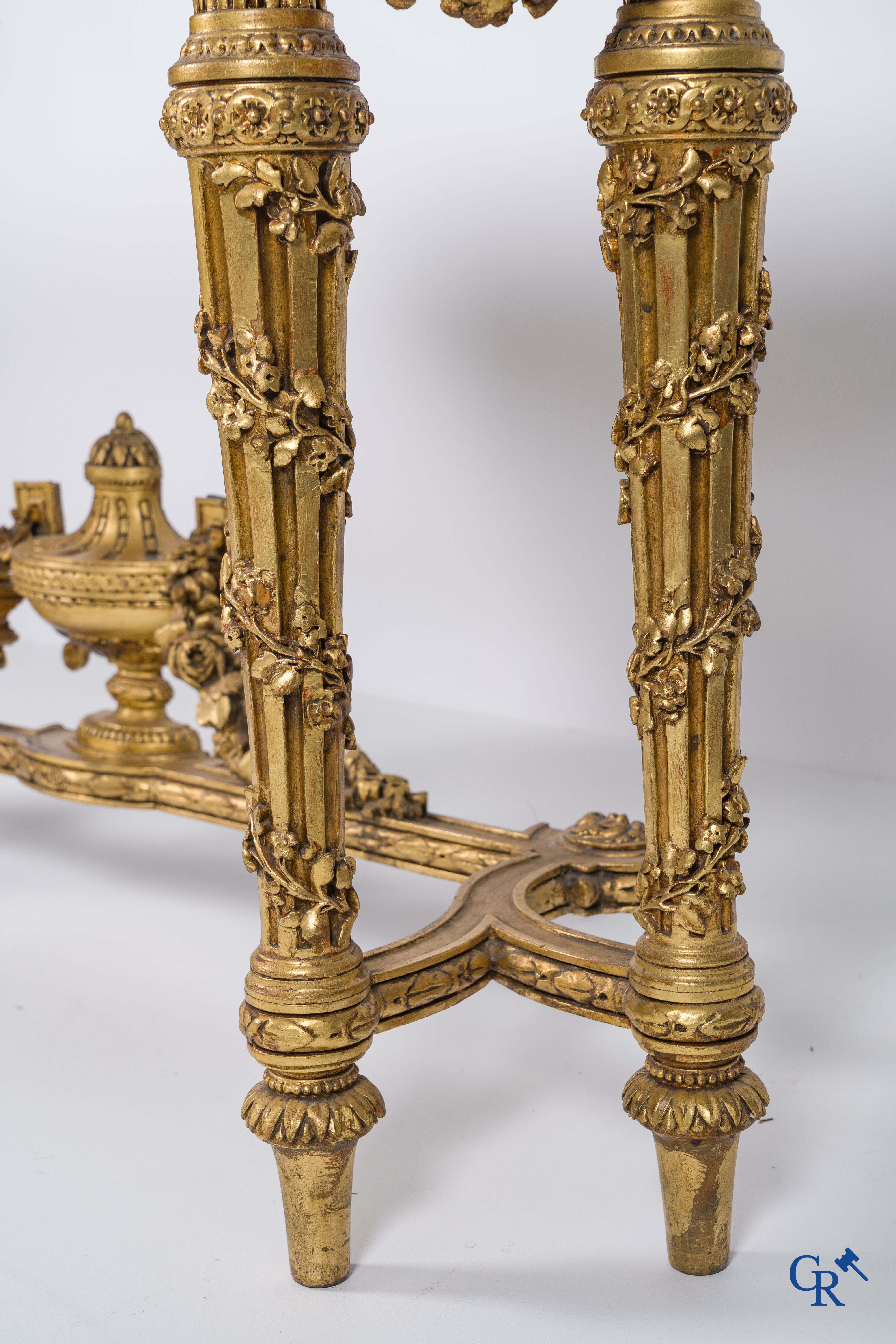 A richly carved and gilded console table in LVXI style with a grisaille painting on marble.