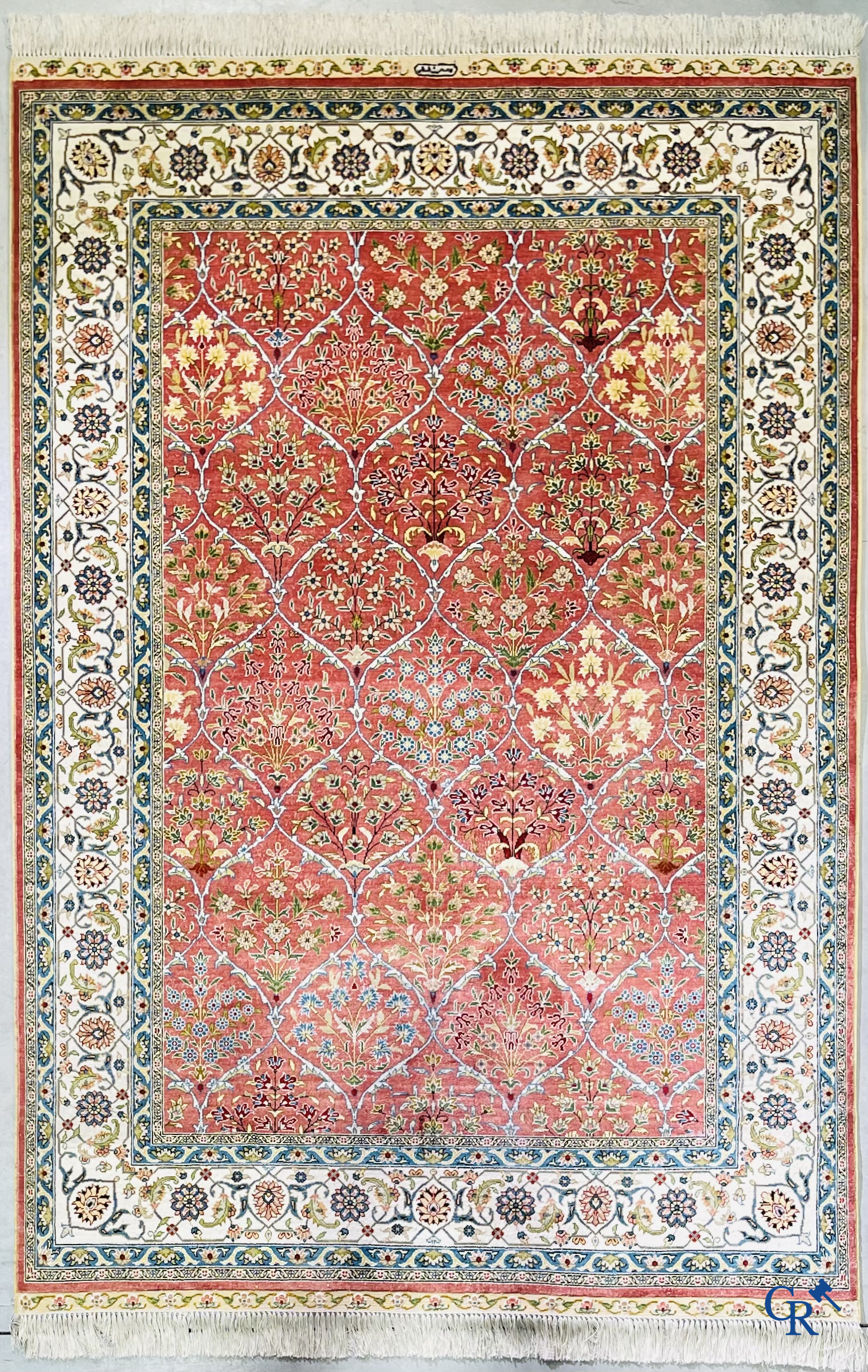 Tapis d'Orient: Un tapis finement noué à la main en laine et soie avec un décor floral.<br />
Signé.