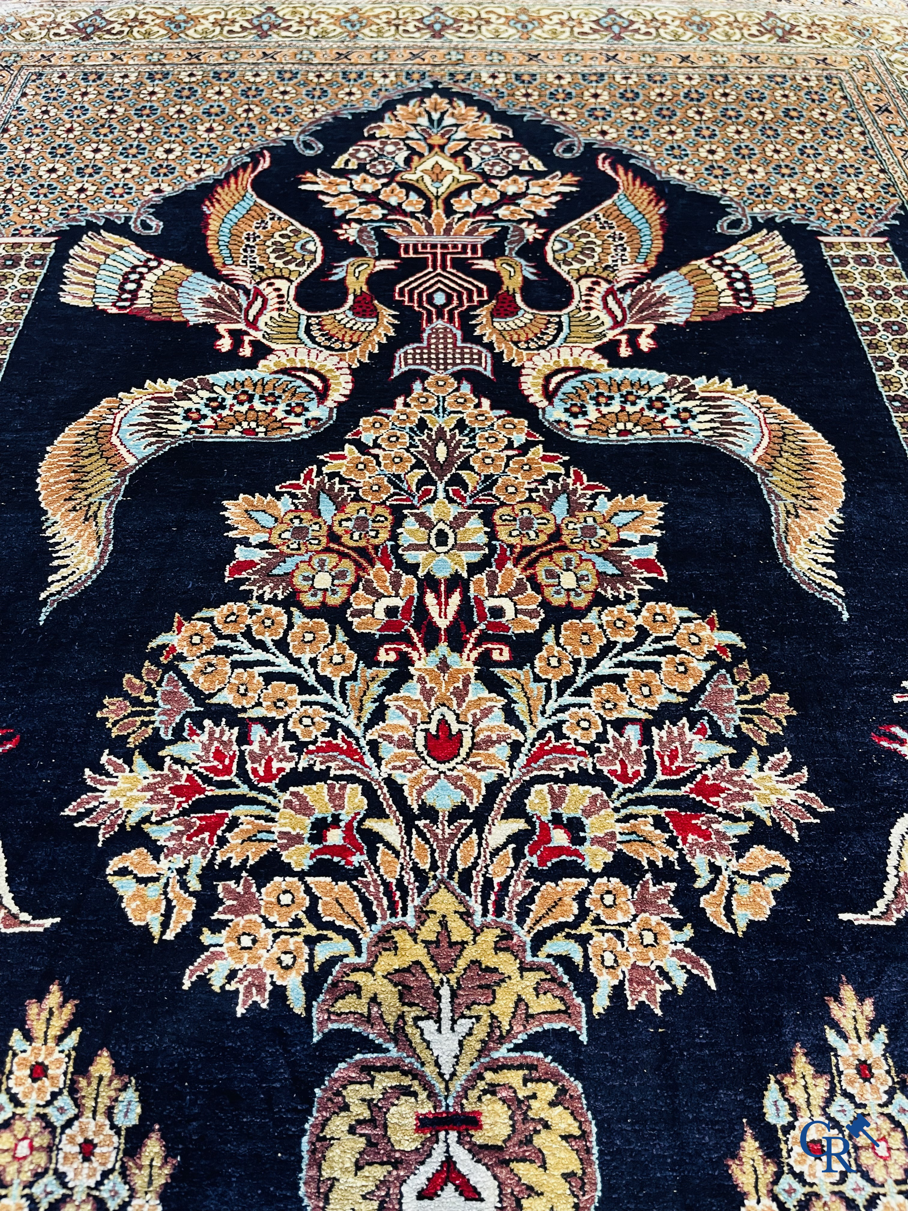 Tapis persans: Un tapis Ghoum en soie, finement noué avec un décor d'oiseaux et de fleurs.