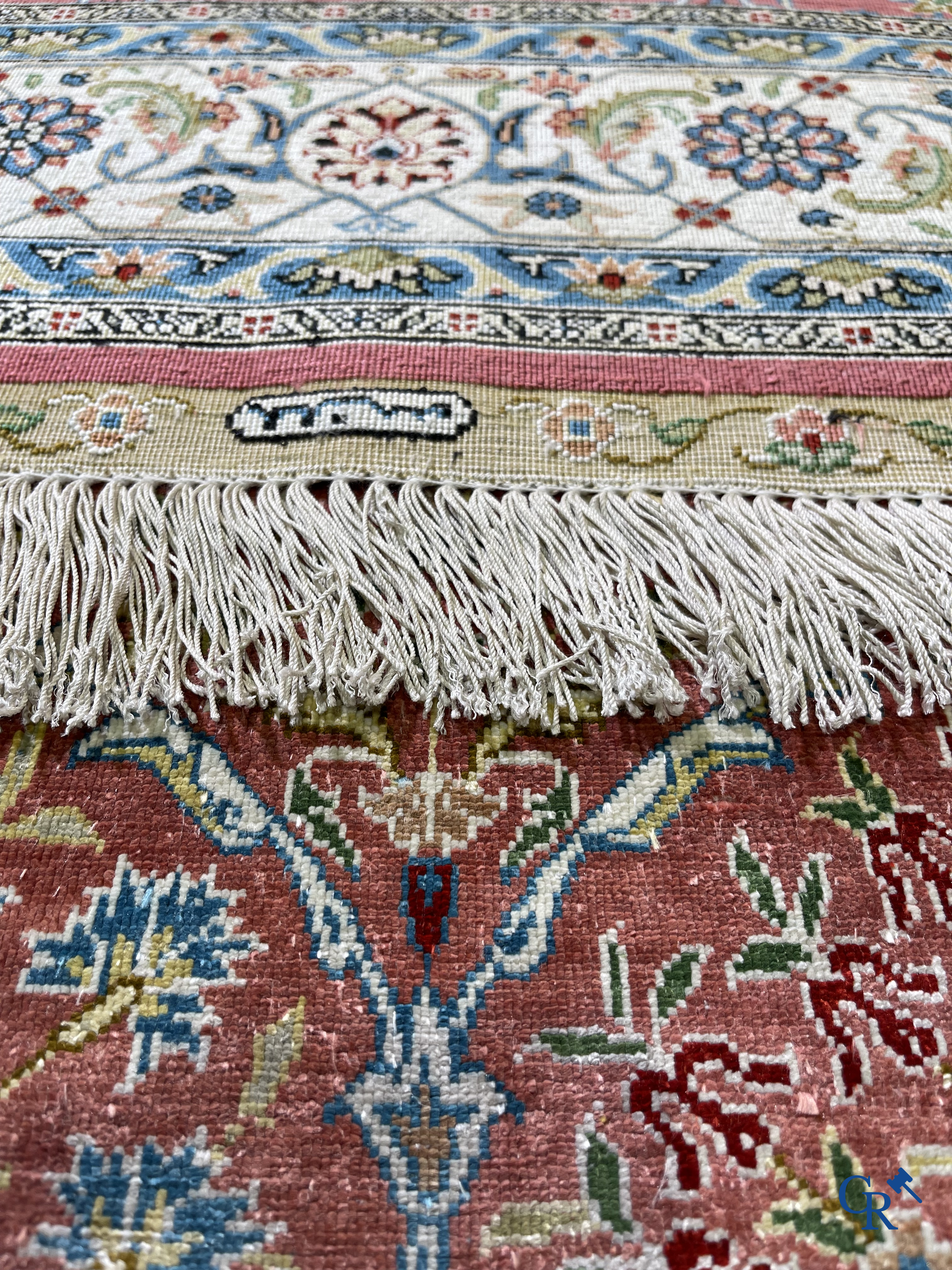 Tapis d'Orient: Un tapis finement noué à la main en laine et soie avec un décor floral.<br />
Signé.