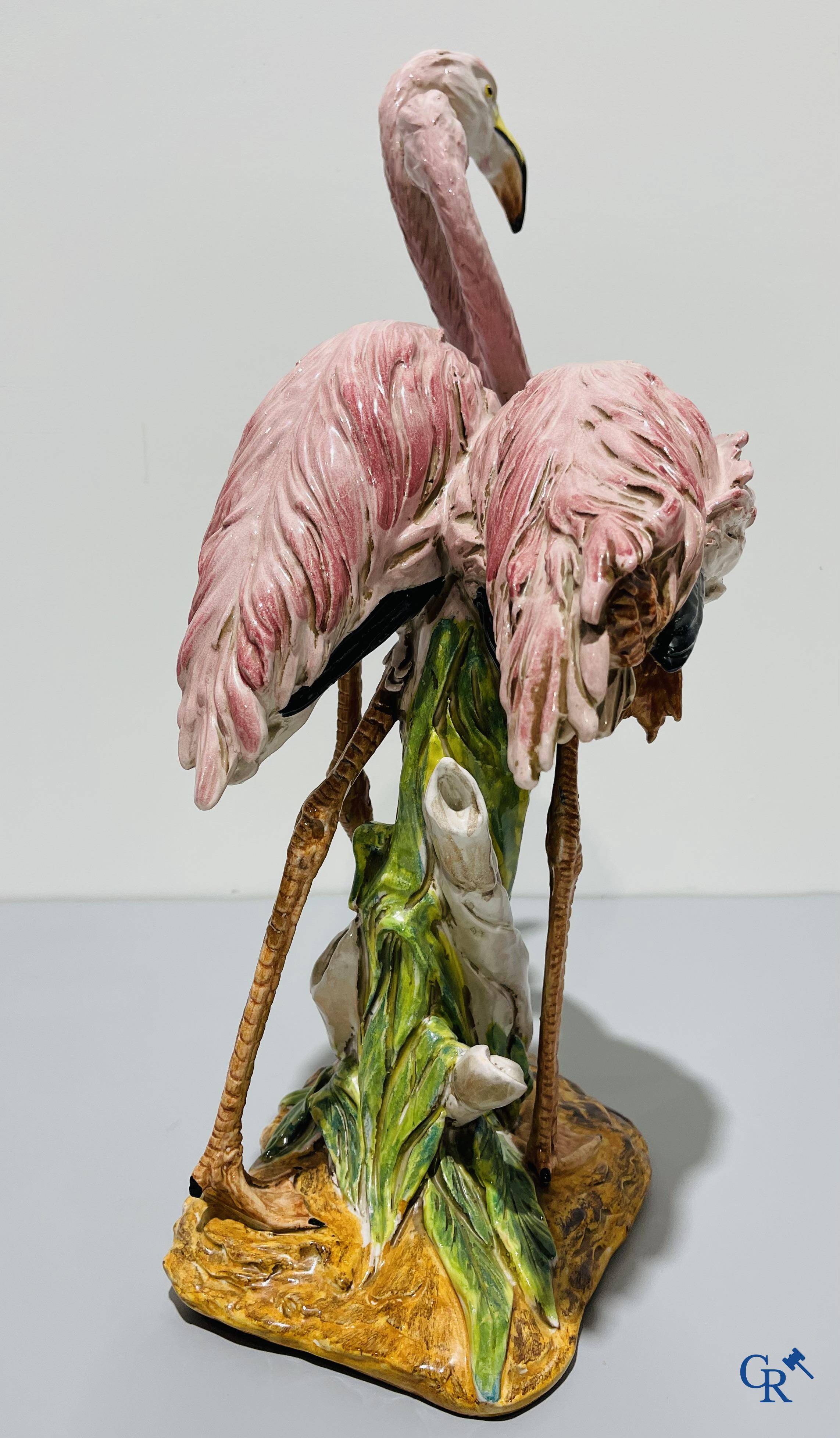 Een paar flamingo's in majolica in de stijl van Massier.